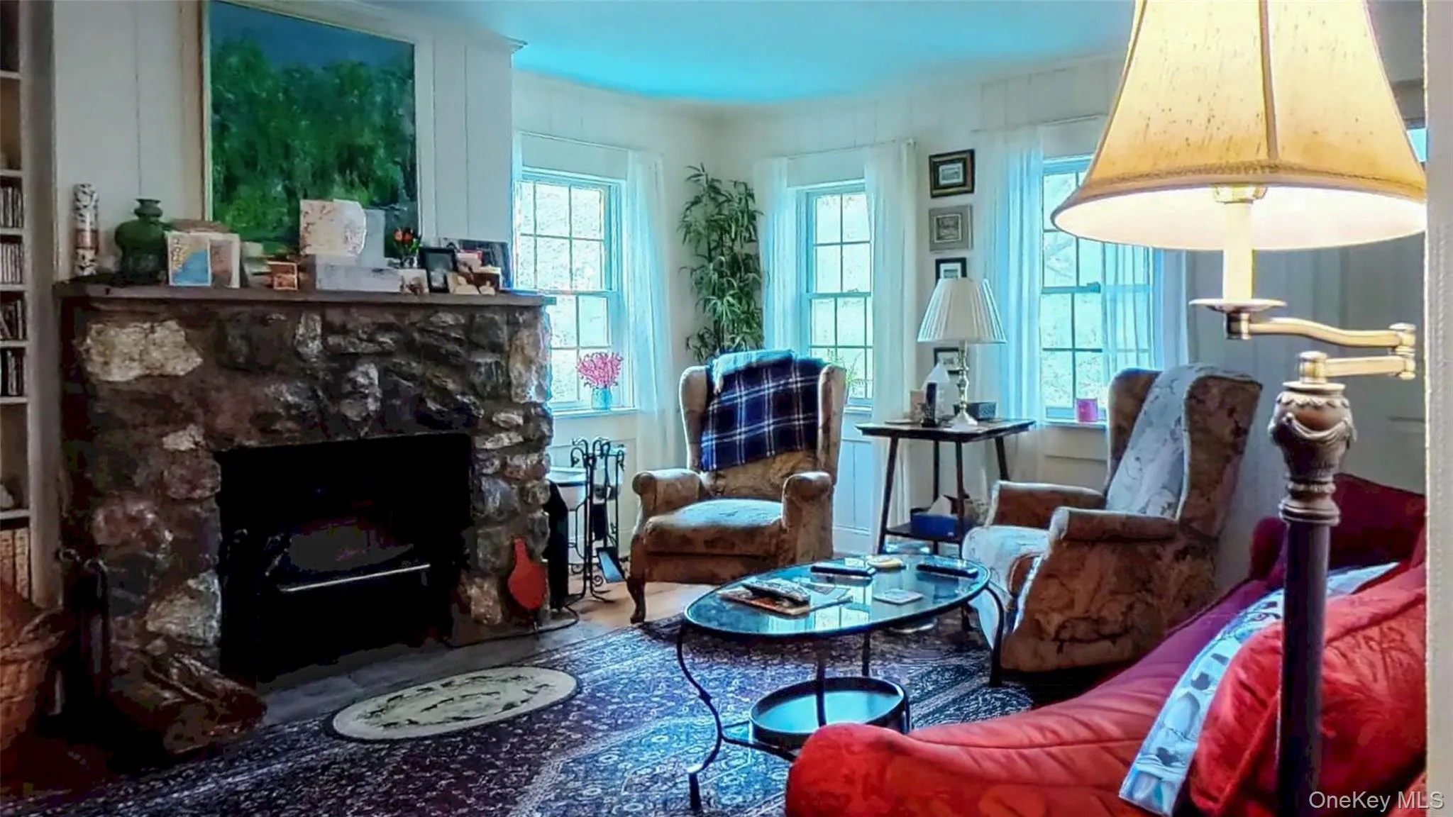 Living room featuring a stone wood fireplace and wide plank floors Living room featuring a stone wood fireplace and wide plank floors
