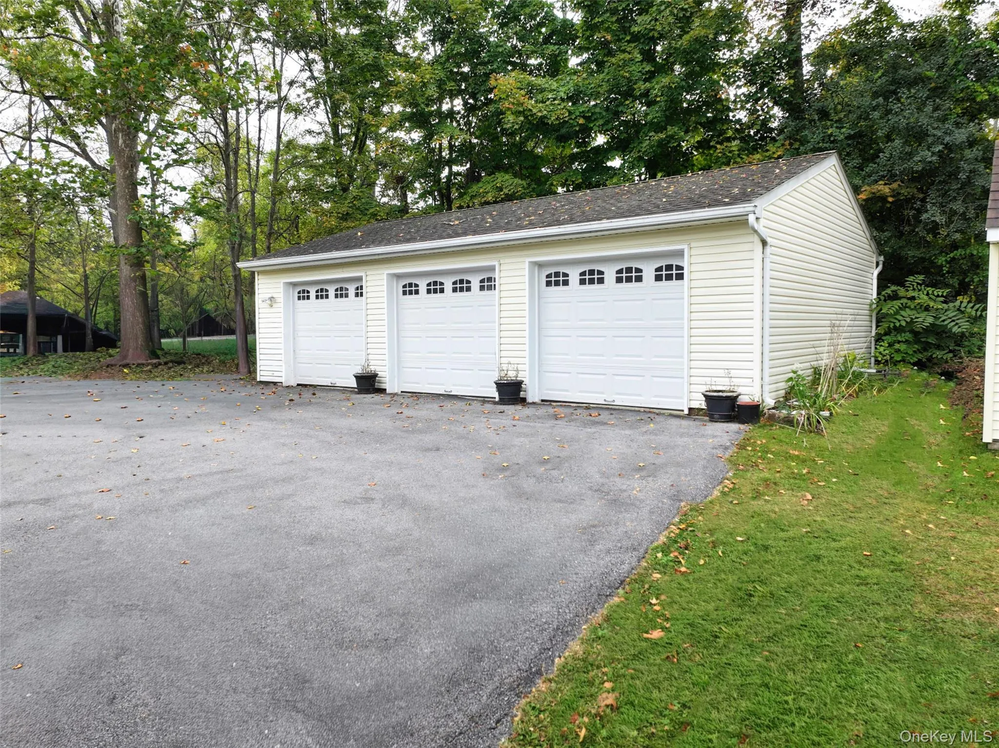 Detached 3 car garage with storage and a paved driveway Detached 3 car garage with storage and a paved driveway