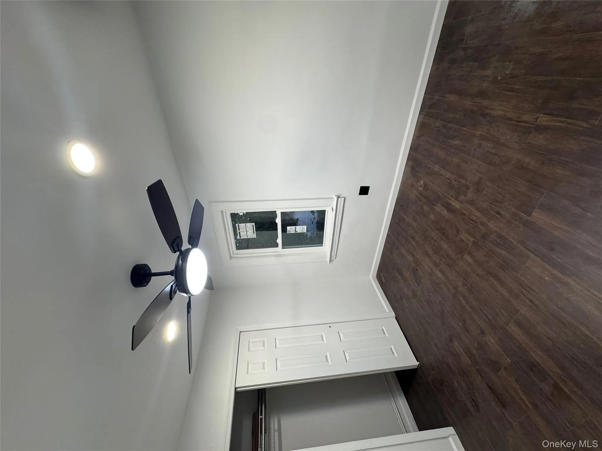 Unfurnished bedroom featuring dark wood-style flooring, ceiling fan, and a closet Unfurnished bedroom featuring dark wood-style flooring, ceiling fan, and a closet