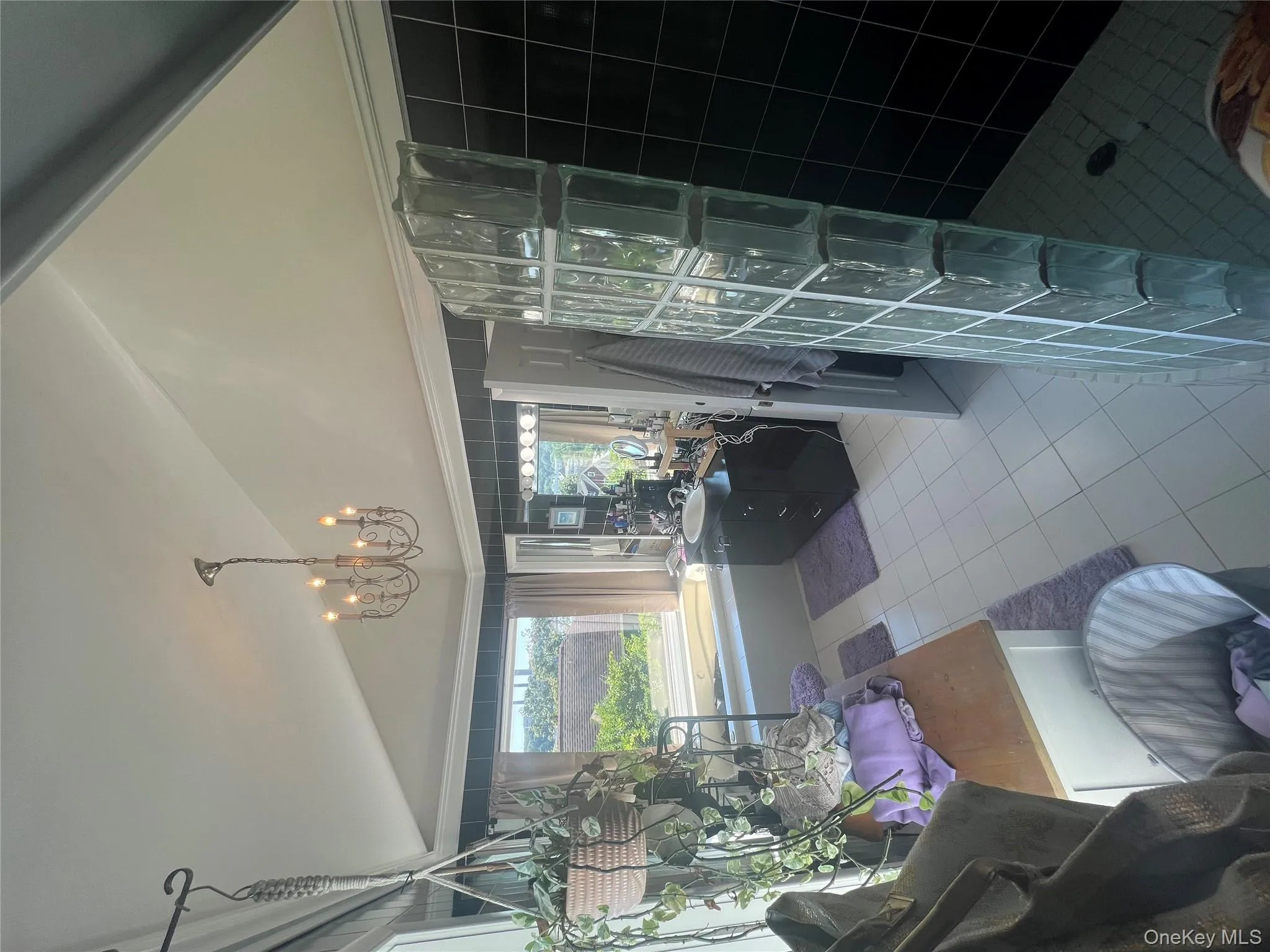 Bathroom with light tile patterned flooring, vanity, vaulted ceiling, walk in shower, and a chandelier Bathroom with light tile patterned flooring, vanity, vaulted ceiling, walk in shower, and a chandelier