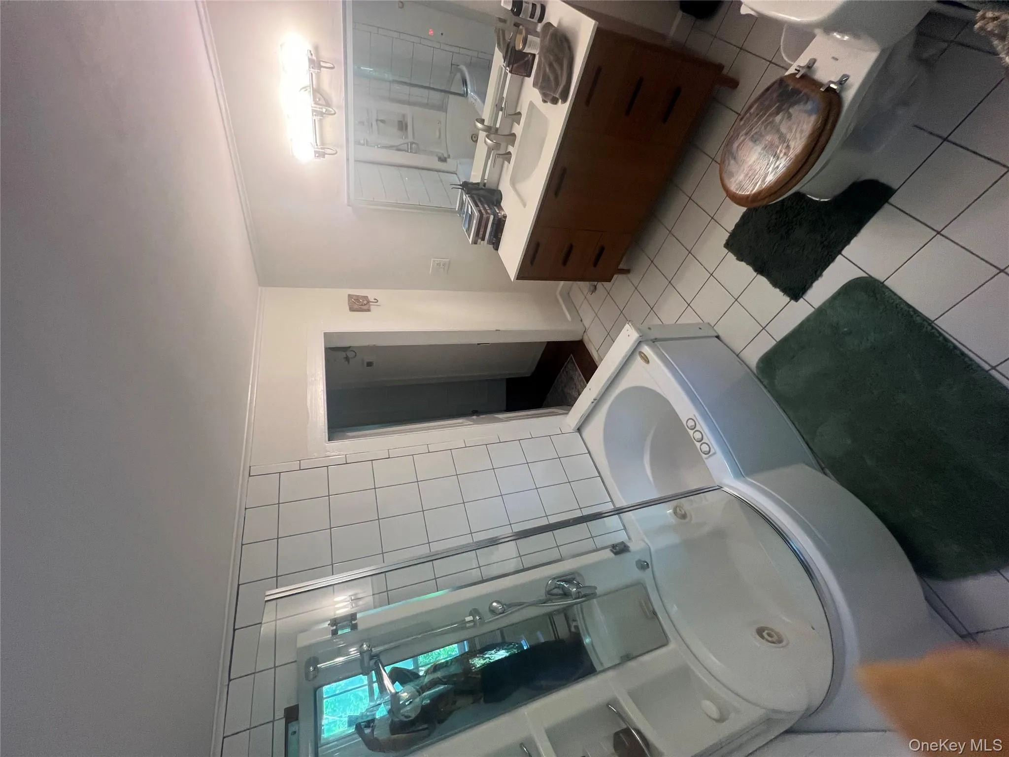 Bathroom featuring a bath, light tile patterned flooring, vanity, a shower with shower door, and crown molding Bathroom featuring a bath, light tile patterned flooring, vanity, a shower with shower door, and crown molding