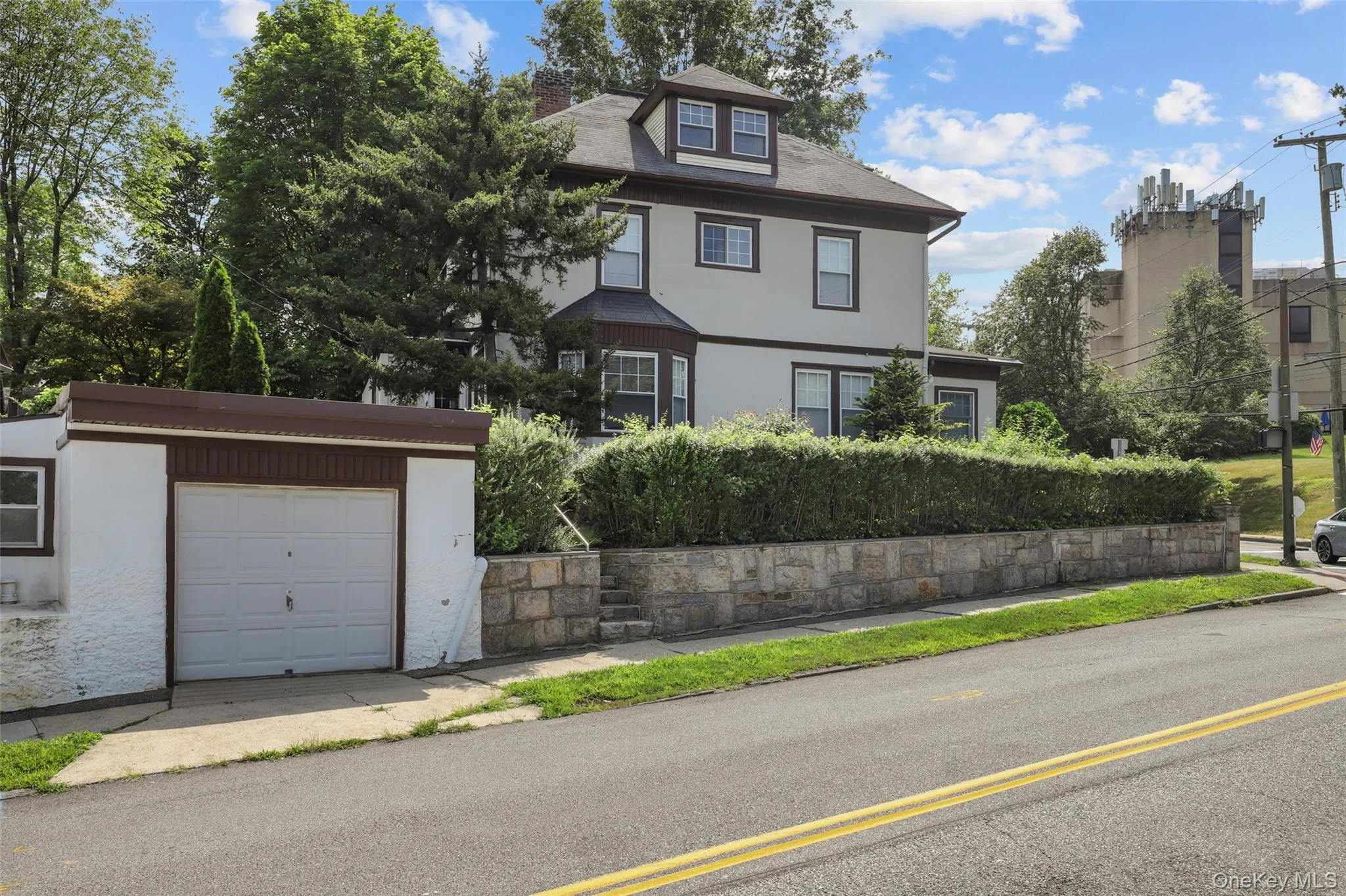 View of front facade featuring stucco siding, a garage, a chimney, and an outdoor structure View of front facade featuring stucco siding, a garage, a chimney, and an outdoor structure