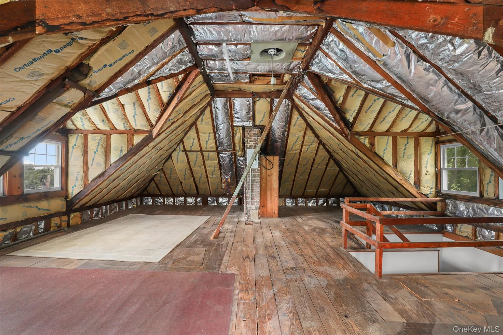 Attic featuring an upstairs landing and plenty of natural light Attic featuring an upstairs landing and plenty of natural light