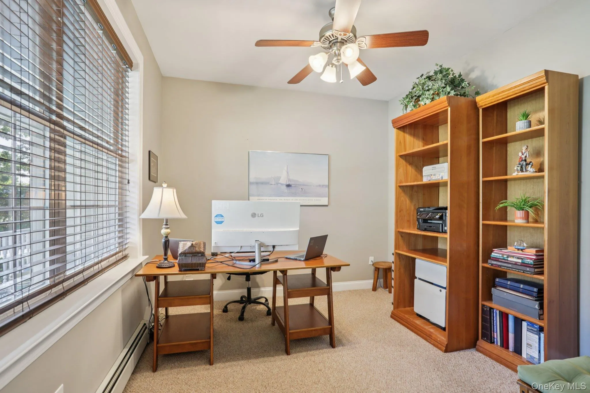 Office featuring light carpet, a baseboard radiator, and ceiling fan Office featuring light carpet, a baseboard radiator, and ceiling fan