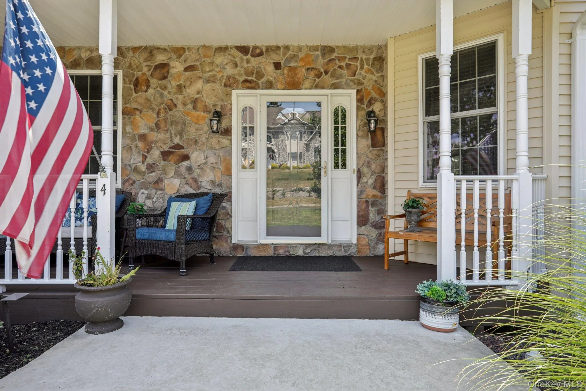 View of exterior entry featuring stone siding and a porch View of exterior entry featuring stone siding and a porch