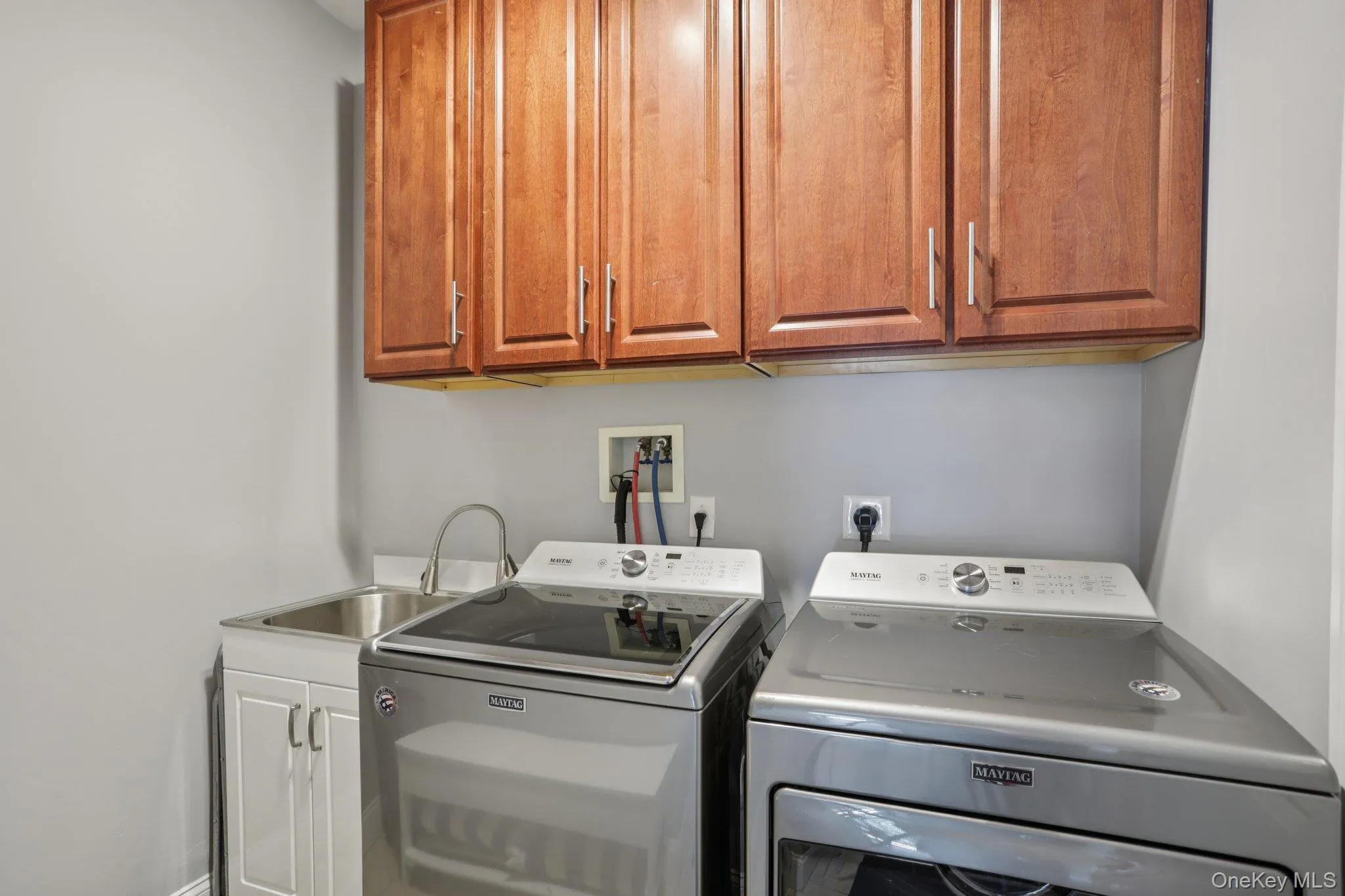 Washroom with cabinet space and washing machine and clothes dryer Washroom with cabinet space and washing machine and clothes dryer