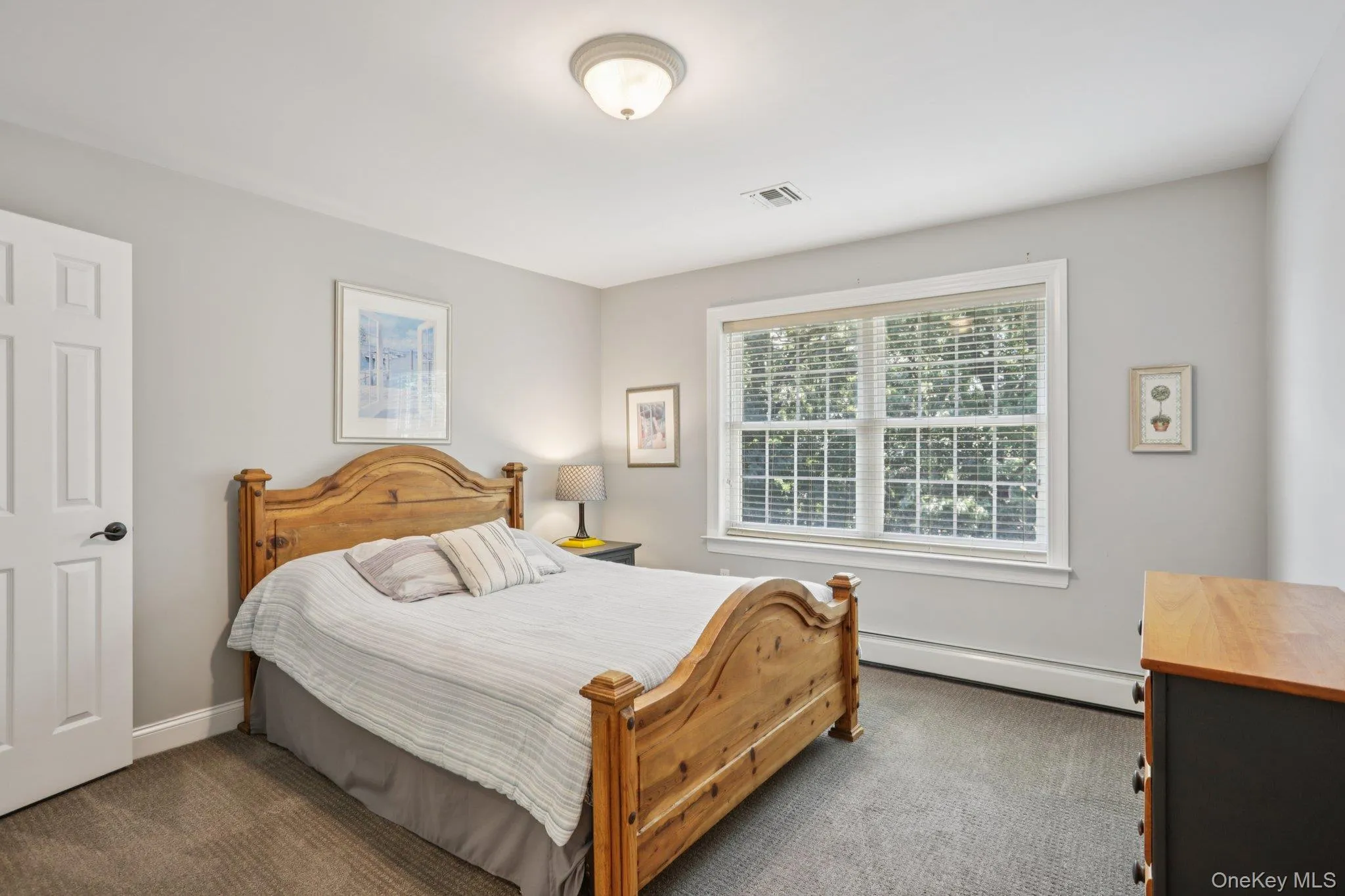 Bedroom featuring dark carpet and baseboard heating Bedroom featuring dark carpet and baseboard heating