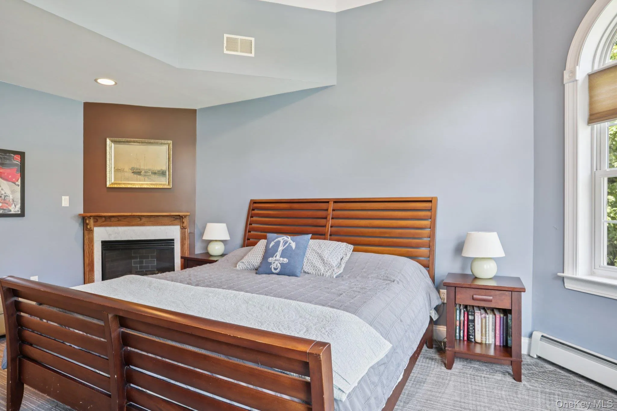 Bedroom featuring a baseboard heating unit, a high end fireplace, and recessed lighting Bedroom featuring a baseboard heating unit, a high end fireplace, and recessed lighting