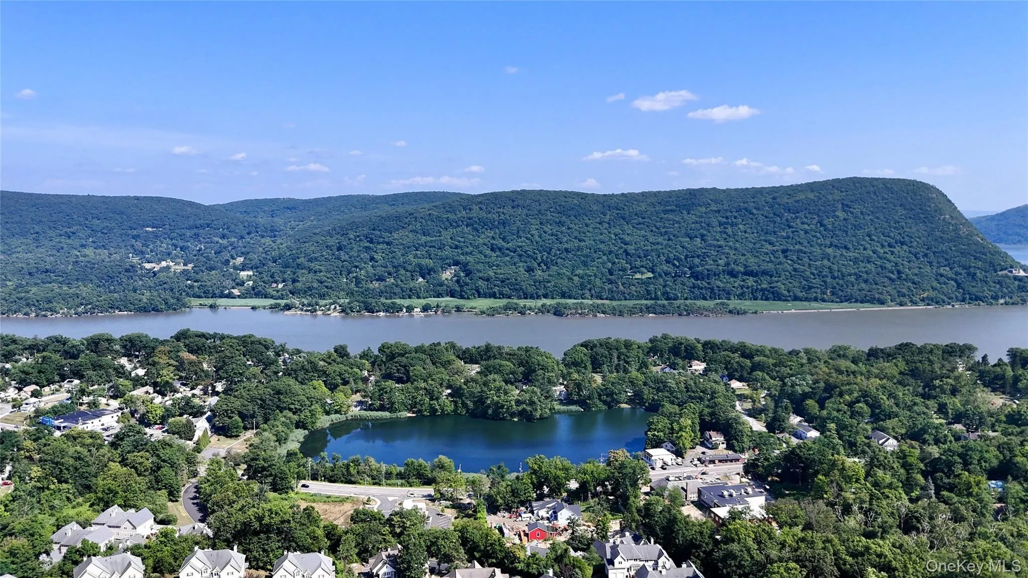 Aerial view of a water and mountain view and a heavily wooded area Aerial view of a water and mountain view and a heavily wooded area