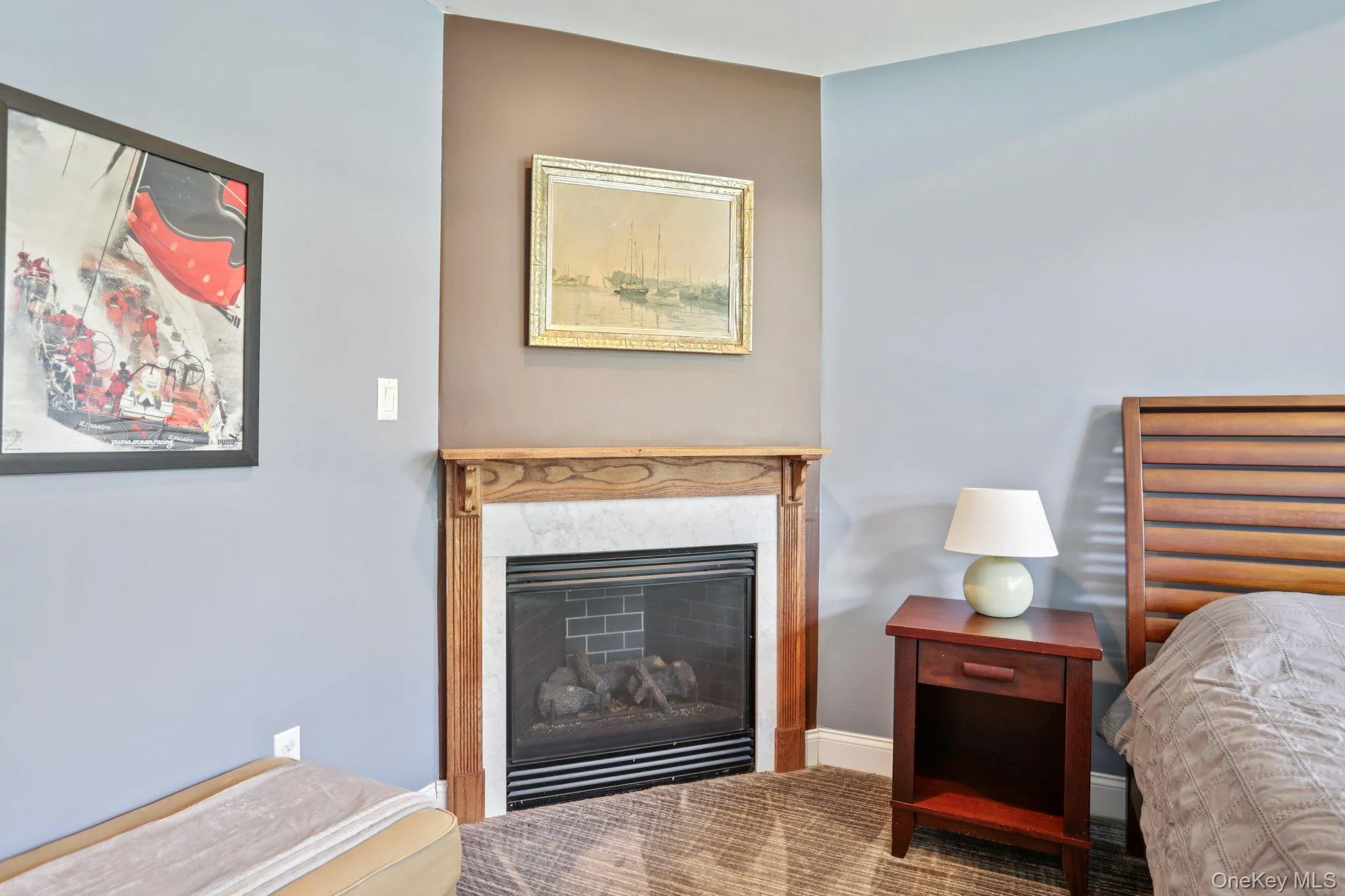 Carpeted bedroom featuring a fireplace and baseboards Carpeted bedroom featuring a fireplace and baseboards