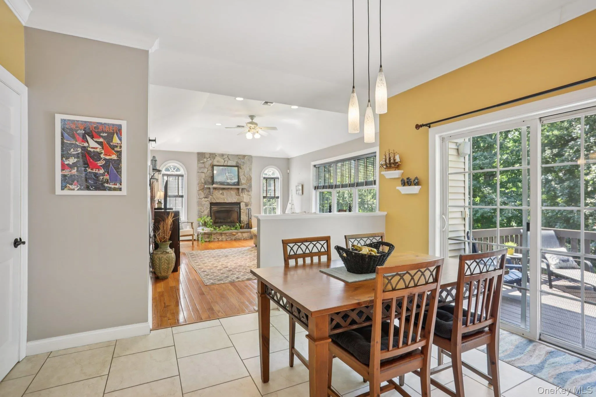 Dining space featuring light tile patterned floors, a ceiling fan, and a fireplace Dining space featuring light tile patterned floors, a ceiling fan, and a fireplace