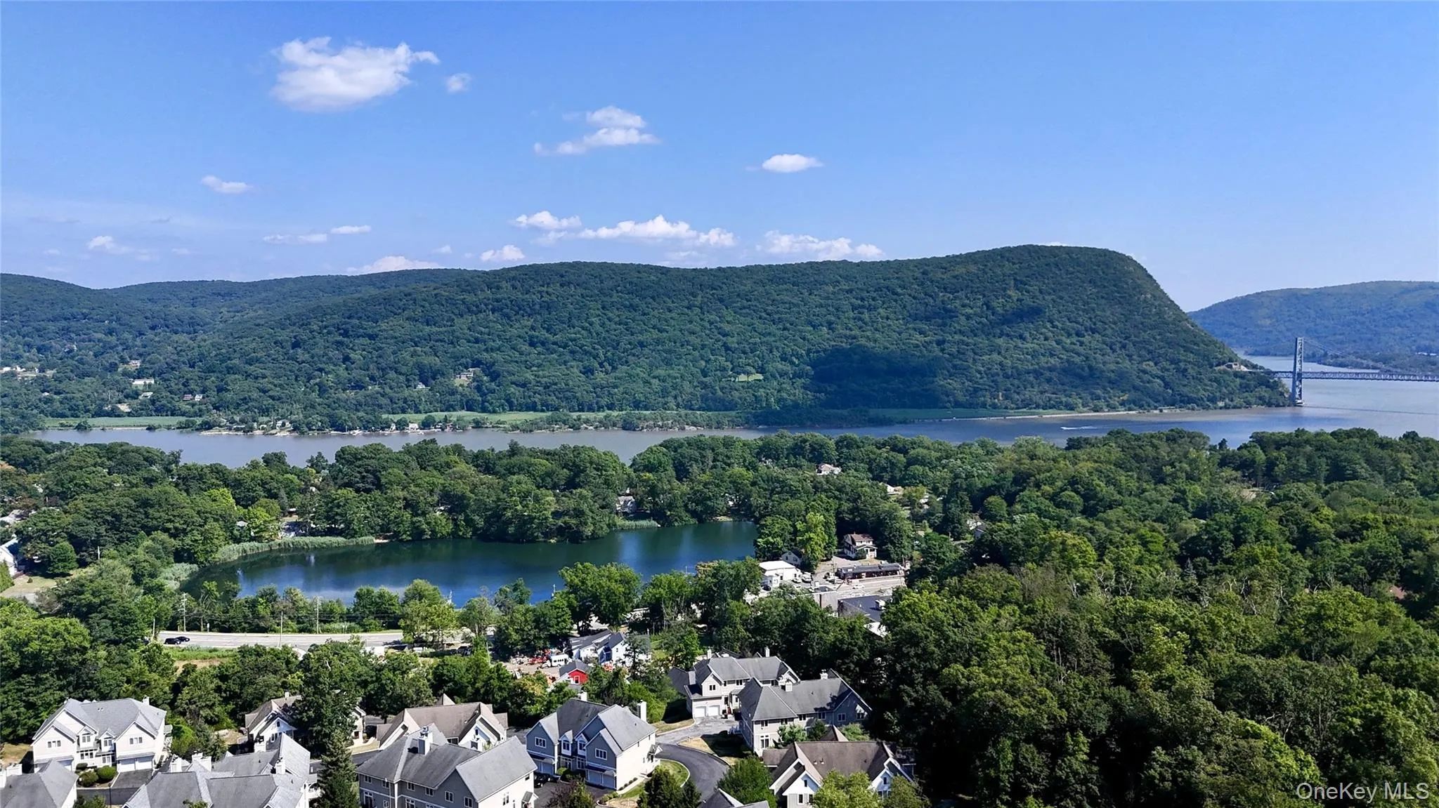 Aerial perspective of suburban area with a forest and a water and mountain view Aerial perspective of suburban area with a forest and a water and mountain view