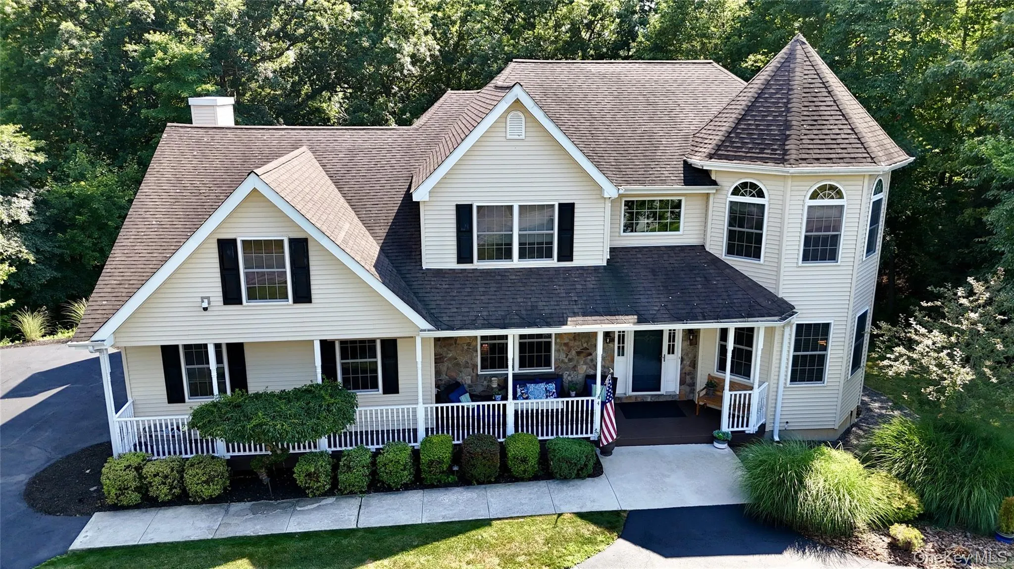View of front facade featuring a porch, a chimney, a shingled roof, and stone siding View of front facade featuring a porch, a chimney, a shingled roof, and stone siding
