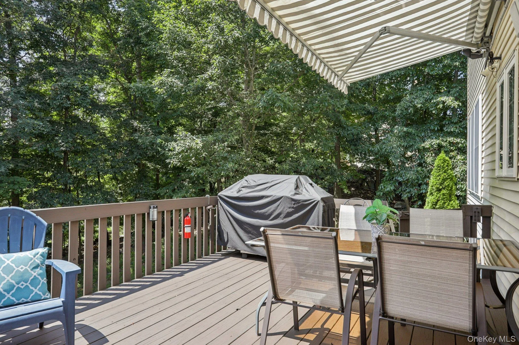 Deck featuring outdoor dining area, area for grilling, and view of wooded area Deck featuring outdoor dining area, area for grilling, and view of wooded area