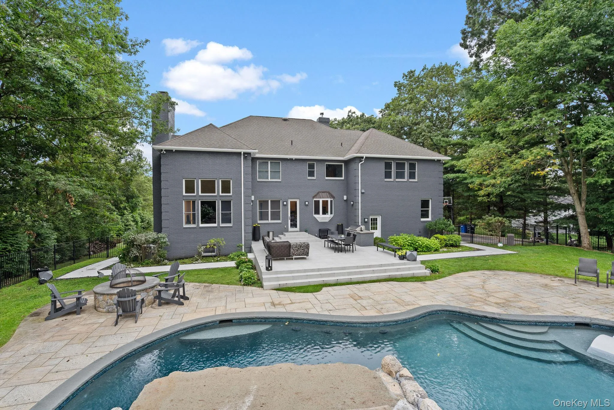 Back of property with an outdoor fire pit, a patio, a chimney, an outdoor pool, and roof with shingles Back of property with an outdoor fire pit, a patio, a chimney, an outdoor pool, and roof with shingles