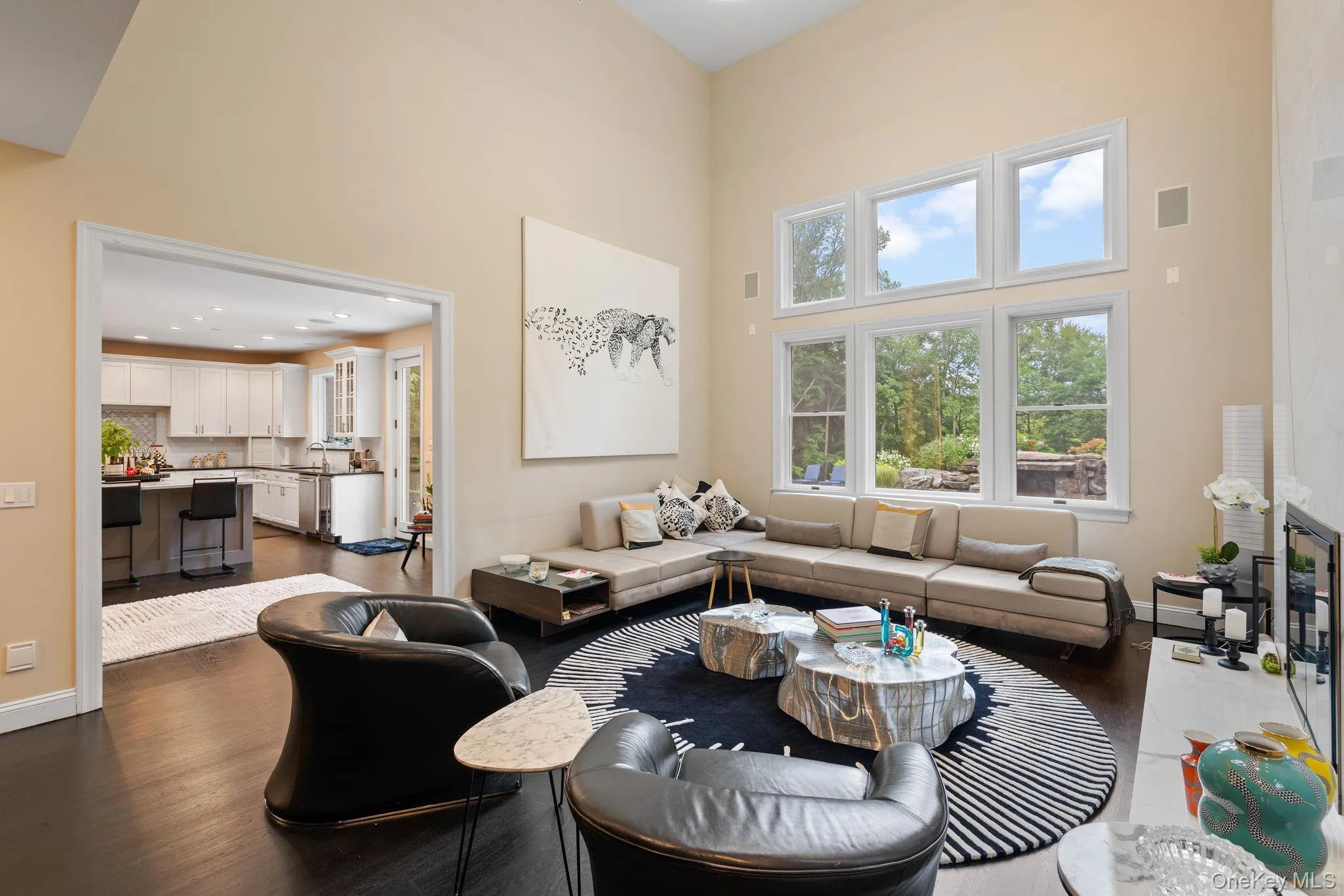 Living room with a towering ceiling, dark wood-style flooring, and recessed lighting Living room with a towering ceiling, dark wood-style flooring, and recessed lighting