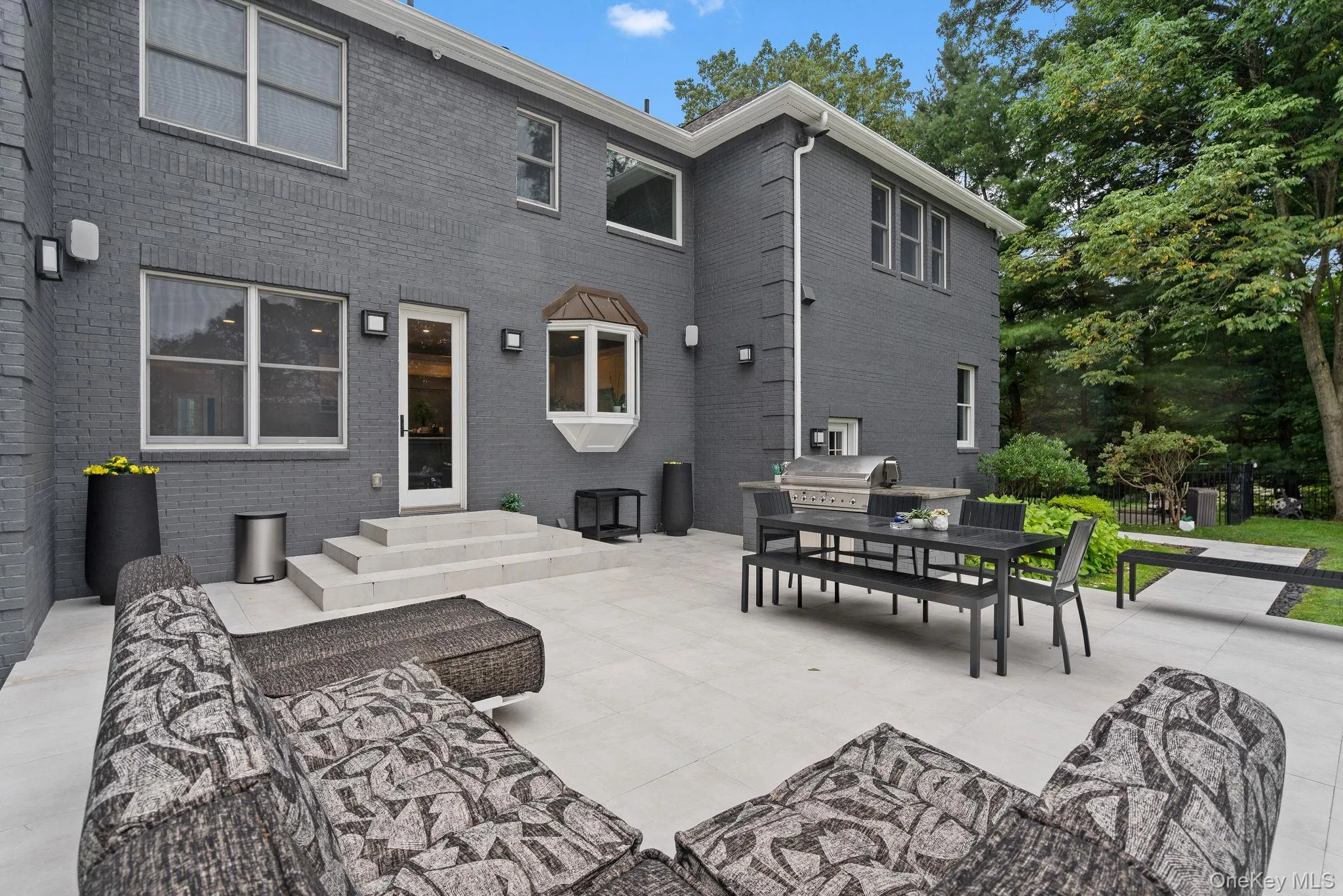 Back of property with a patio, outdoor dining space, and brick siding Back of property with a patio, outdoor dining space, and brick siding