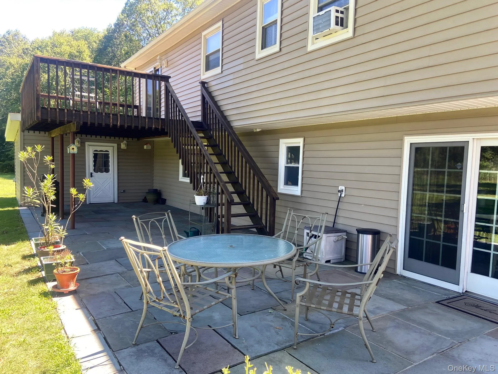 View of patio featuring stairway, a wooden deck, and outdoor dining area View of patio featuring stairway, a wooden deck, and outdoor dining area