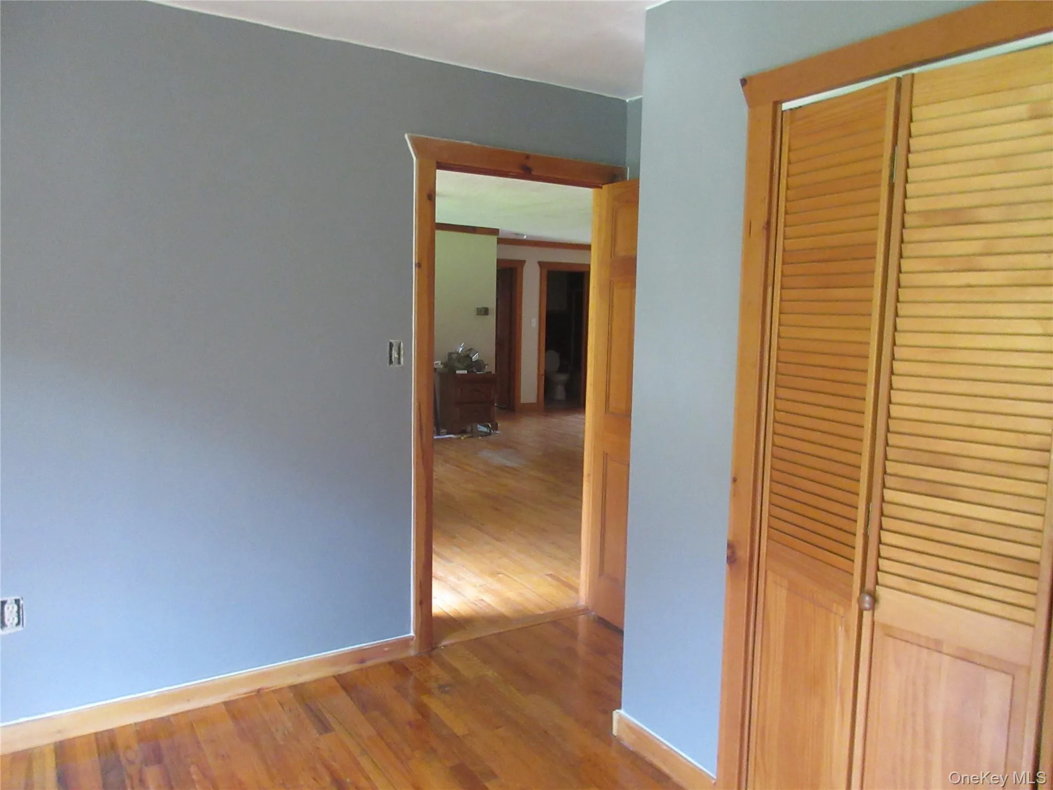 Unfurnished bedroom with wood finished floors and a closet Unfurnished bedroom with wood finished floors and a closet