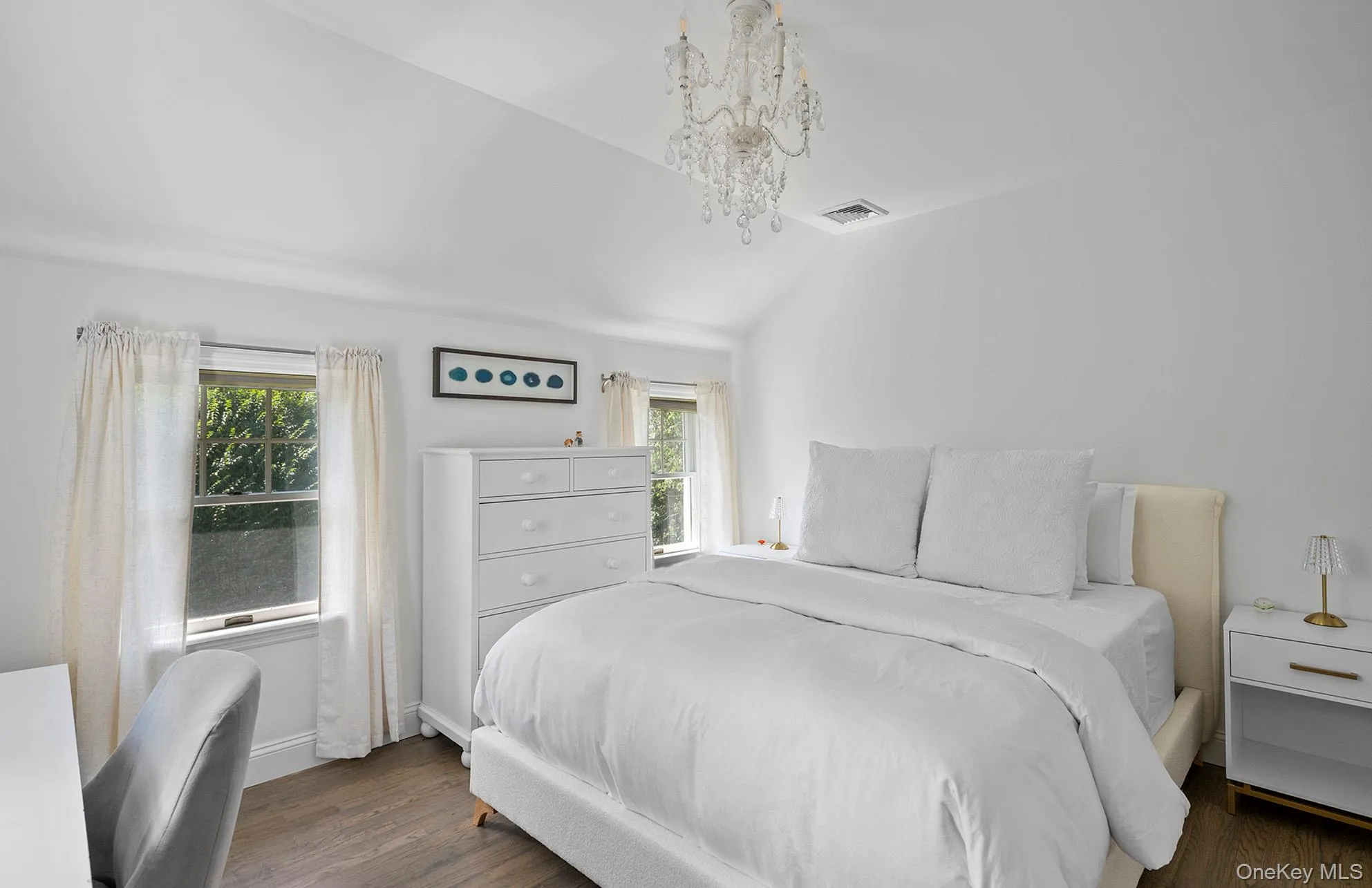 Bedroom with vaulted ceiling, multiple windows, dark wood-style flooring, and a chandelier Bedroom with vaulted ceiling, multiple windows, dark wood-style flooring, and a chandelier