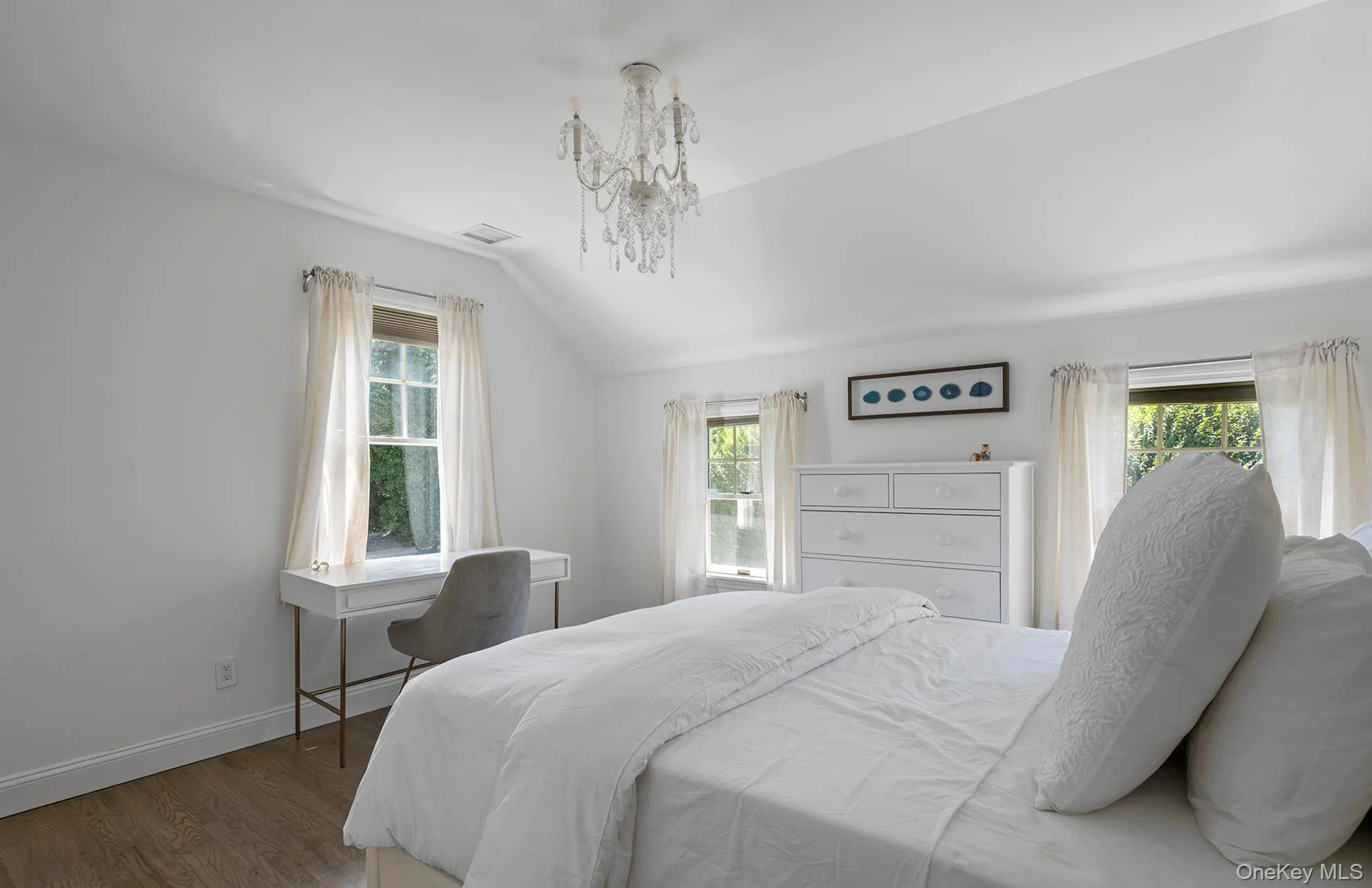 Bedroom featuring wood finished floors and vaulted ceiling Bedroom featuring wood finished floors and vaulted ceiling