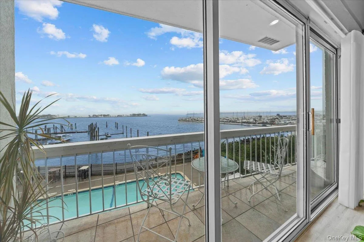 Livingroom balcony featuring a water view and view of pool area Livingroom balcony featuring a water view and view of pool area