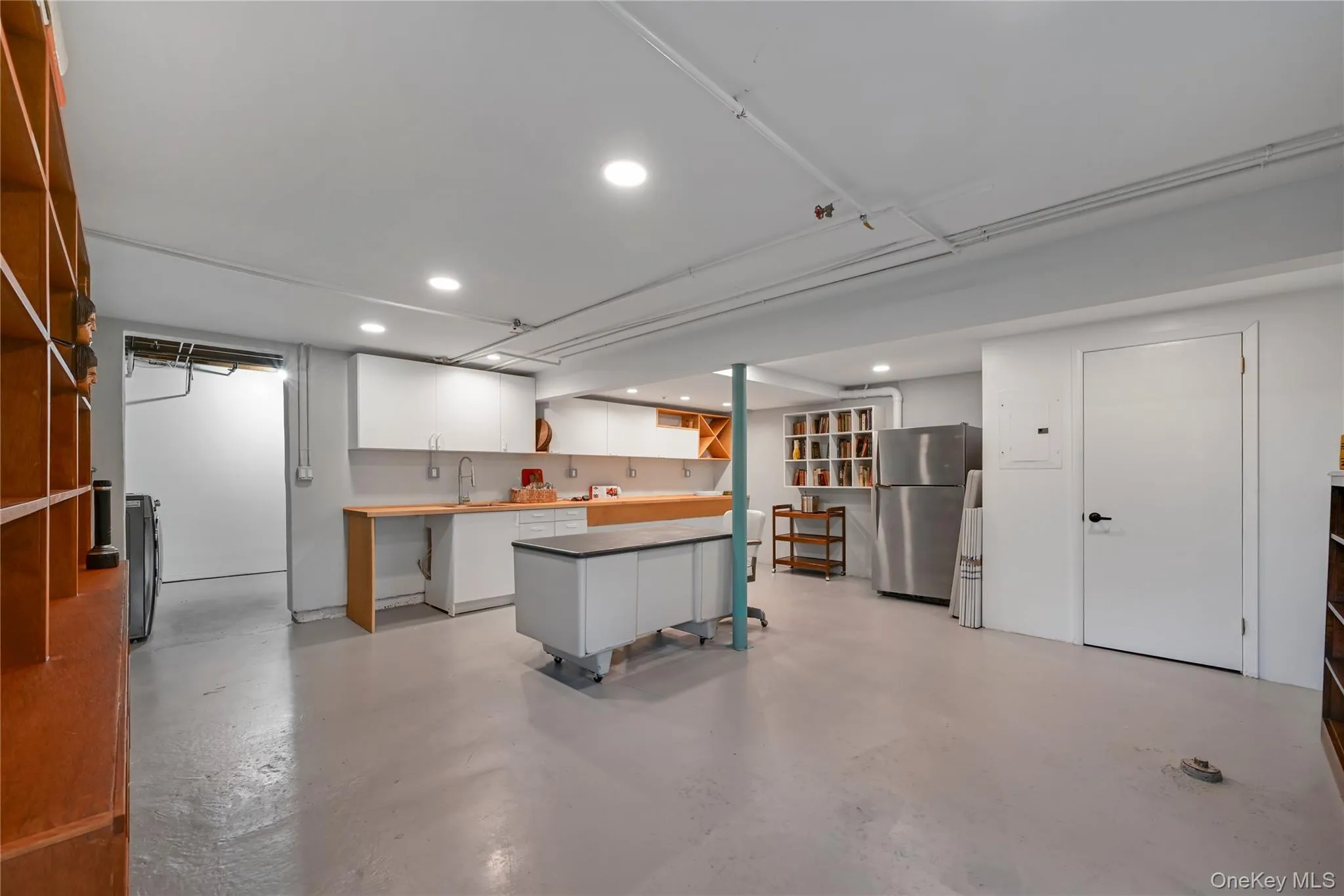 Finished basement featuring recessed lighting, freestanding refrigerator, and washing machine and clothes dryer Finished basement featuring recessed lighting, freestanding refrigerator, and washing machine and clothes dryer