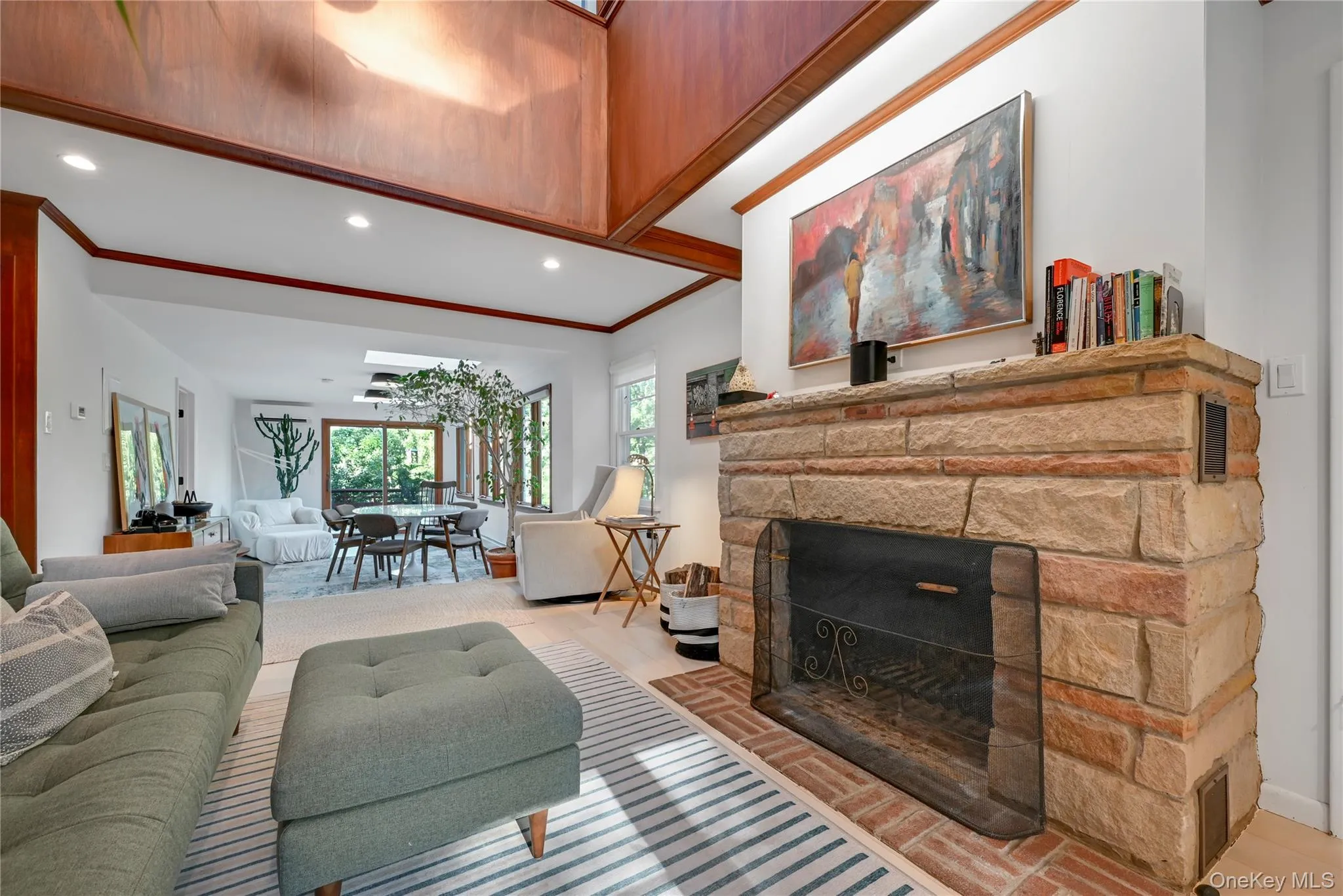 Living area featuring a fireplace, crown molding, recessed lighting, and light wood-style flooring Living area featuring a fireplace, crown molding, recessed lighting, and light wood-style flooring