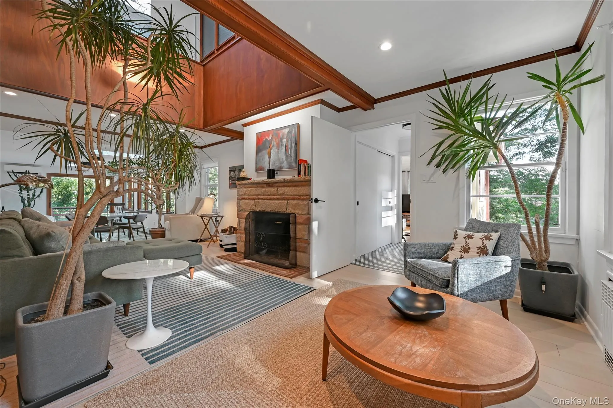 Living area with a stone fireplace, plenty of natural light, crown molding, and recessed lighting Living area with a stone fireplace, plenty of natural light, crown molding, and recessed lighting