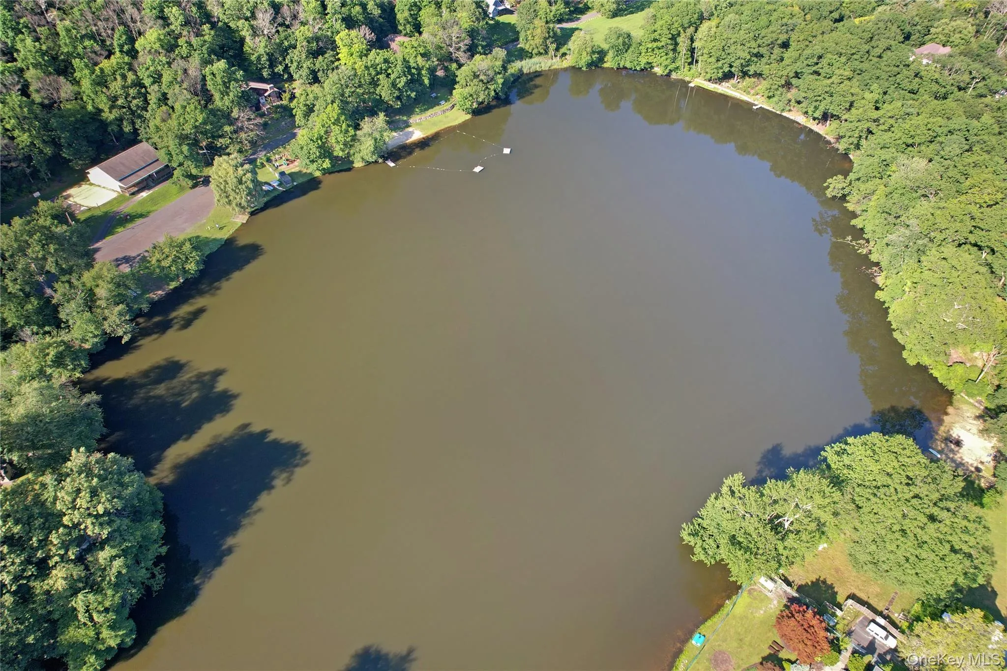 Aerial overview of property's location with a large body of water and a heavily wooded area Aerial overview of property's location with a large body of water and a heavily wooded area