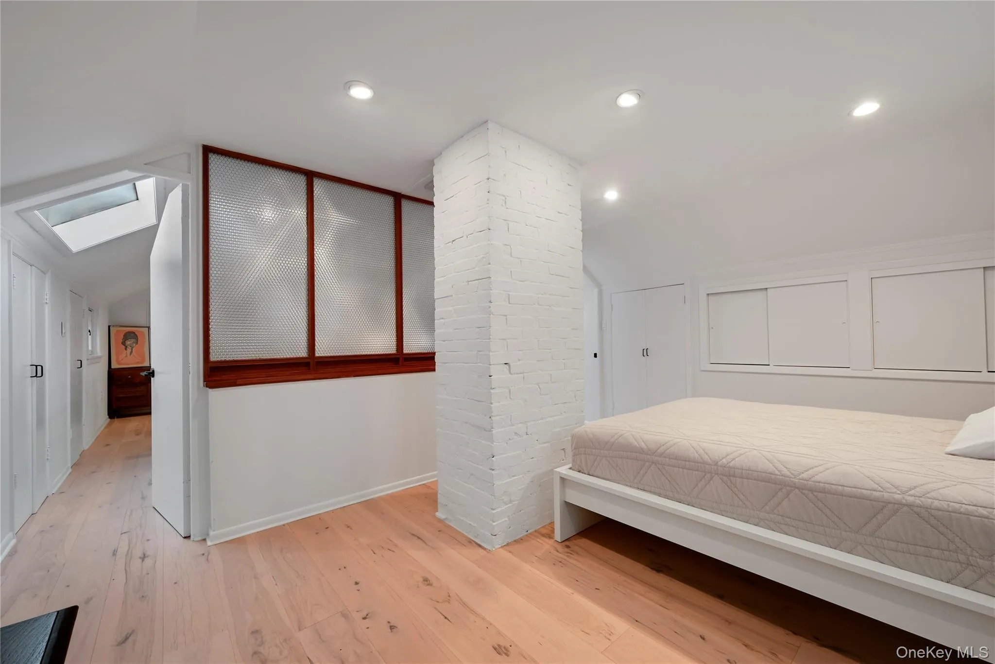 Bedroom featuring vaulted ceiling, light wood-type flooring, a skylight, and recessed lighting Bedroom featuring vaulted ceiling, light wood-type flooring, a skylight, and recessed lighting