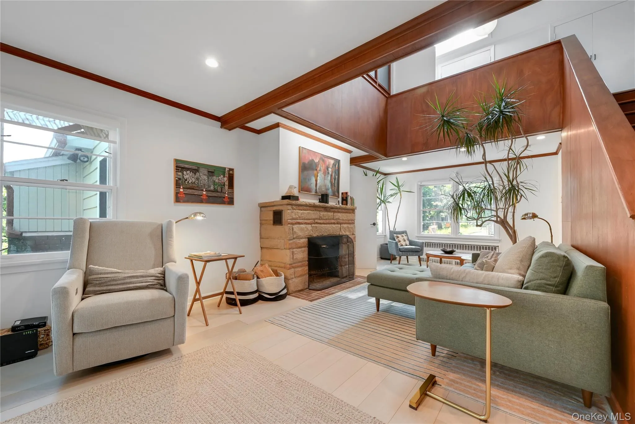 Living room with crown molding, a fireplace, recessed lighting, radiator, and wood finished floors Living room with crown molding, a fireplace, recessed lighting, radiator, and wood finished floors