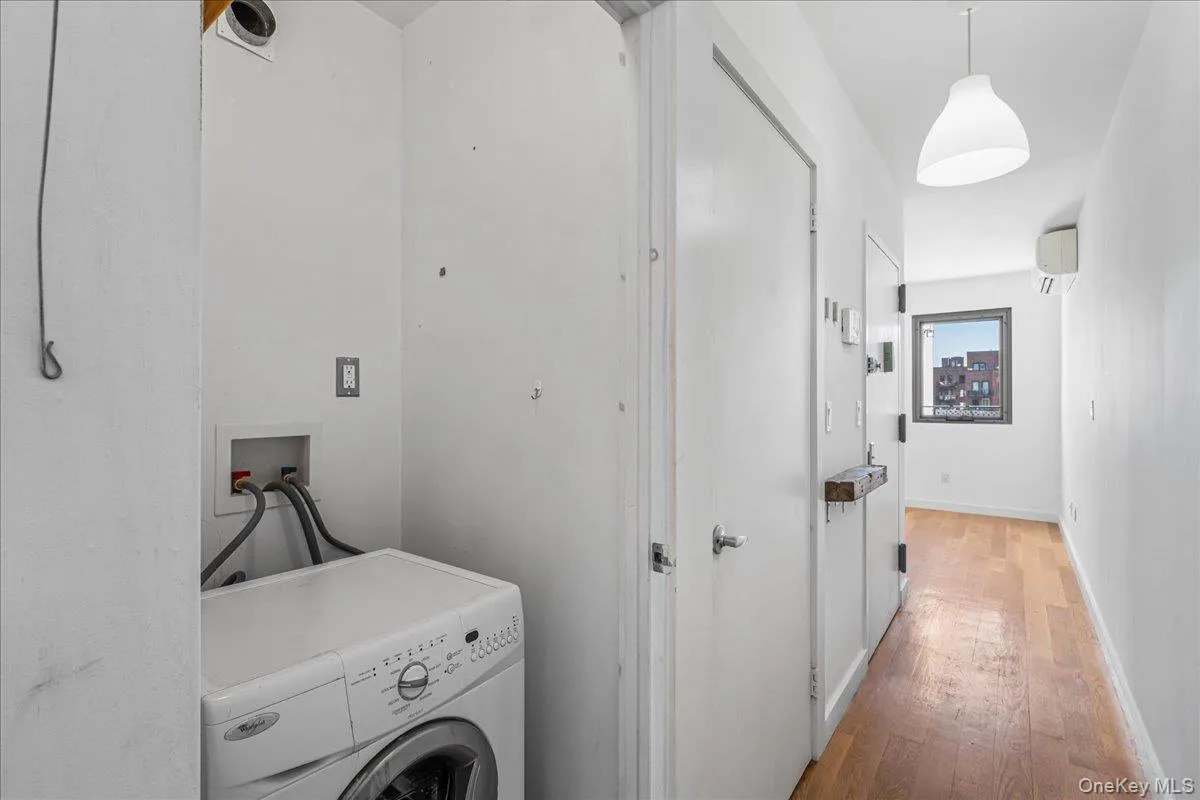 Washroom featuring washer / clothes dryer and hardwood / wood-style floors Washroom featuring washer / clothes dryer and hardwood / wood-style floors