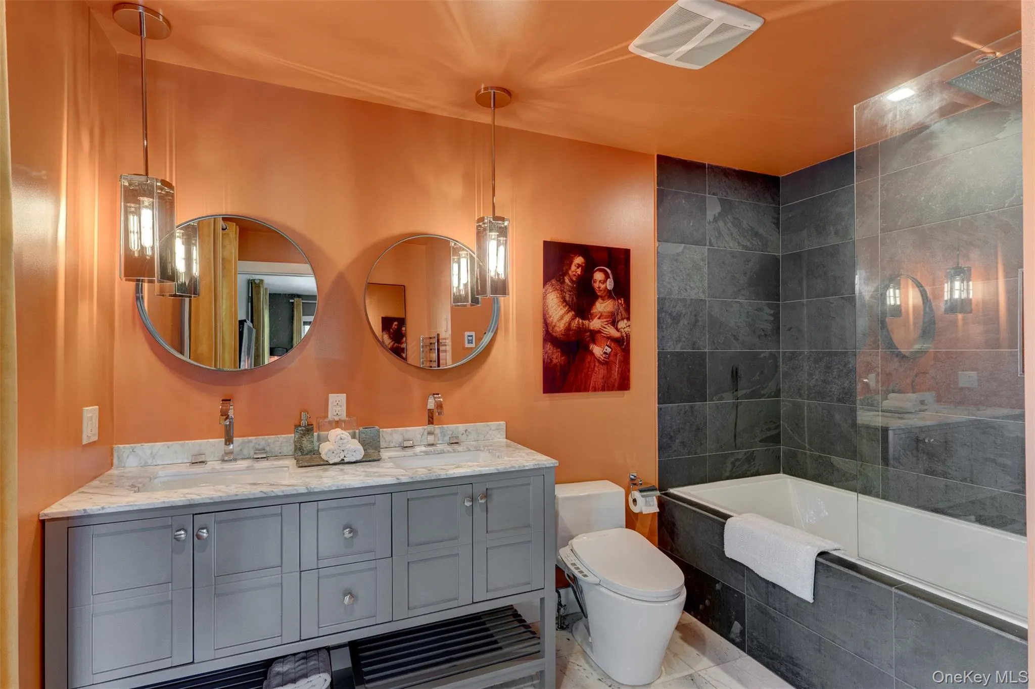 Full bathroom featuring double vanity and tiled shower / bath combo Full bathroom featuring double vanity and tiled shower / bath combo