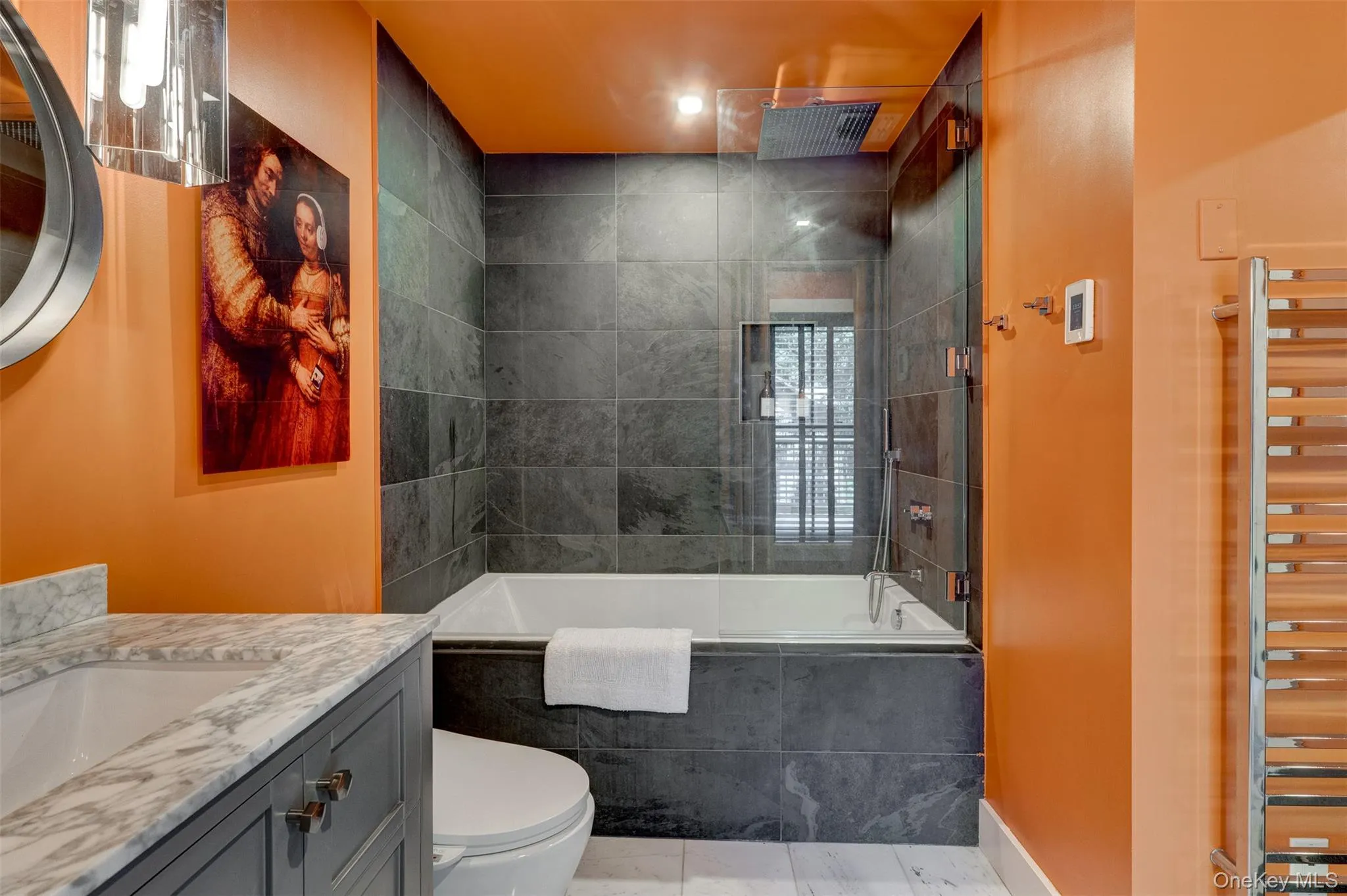 Bathroom featuring a combined bath / shower with rainfall shower, vanity, a towel warming rack, and tile patterned floors Bathroom featuring a combined bath / shower with rainfall shower, vanity, a towel warming rack, and tile patterned floors