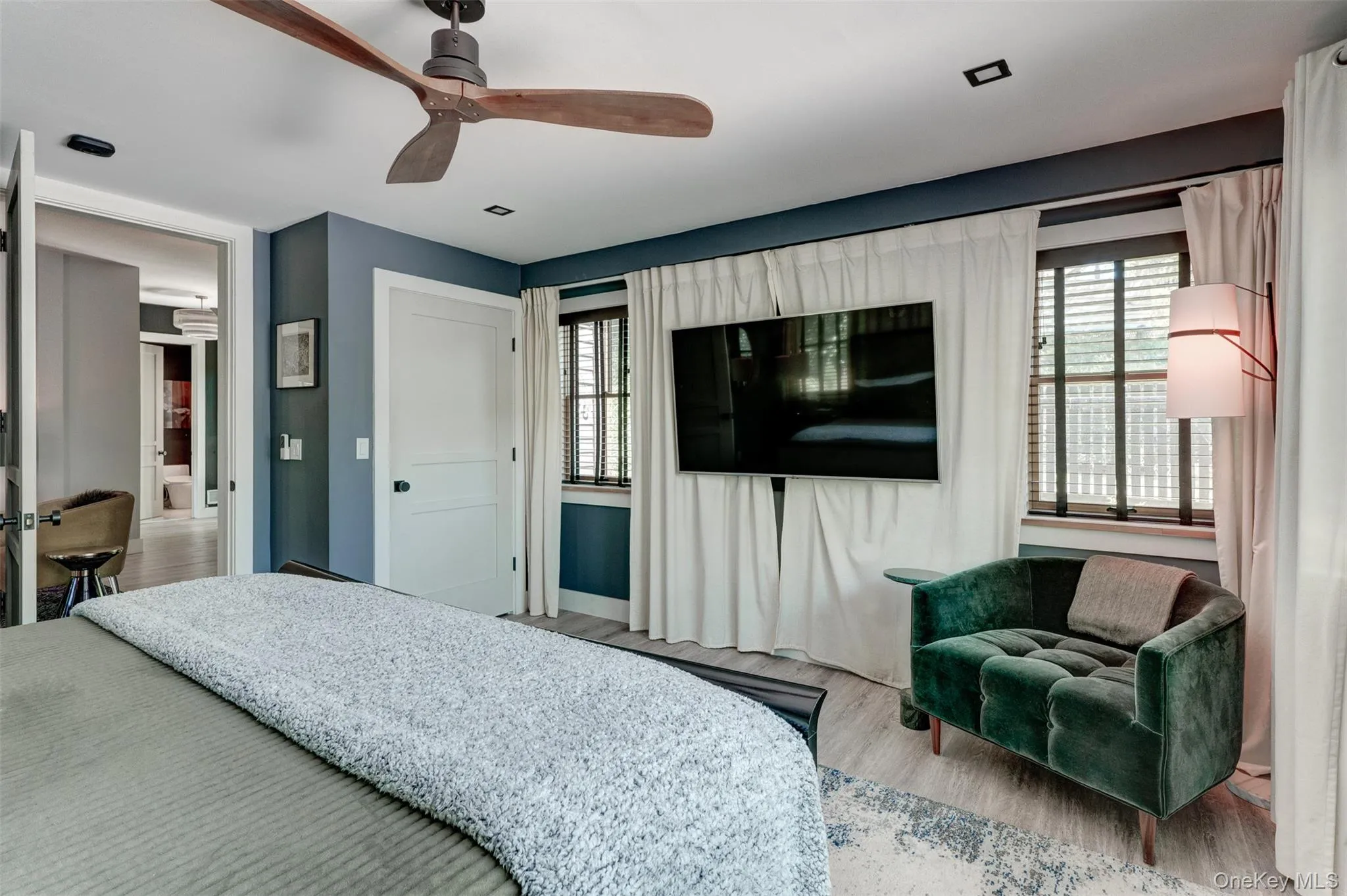 Bedroom with multiple windows, wood finished floors, and a ceiling fan Bedroom with multiple windows, wood finished floors, and a ceiling fan