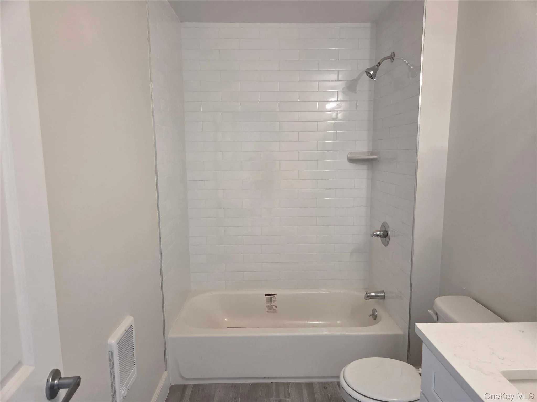 Bathroom featuring shower / tub combination, vanity, and wood finished floors Bathroom featuring shower / tub combination, vanity, and wood finished floors