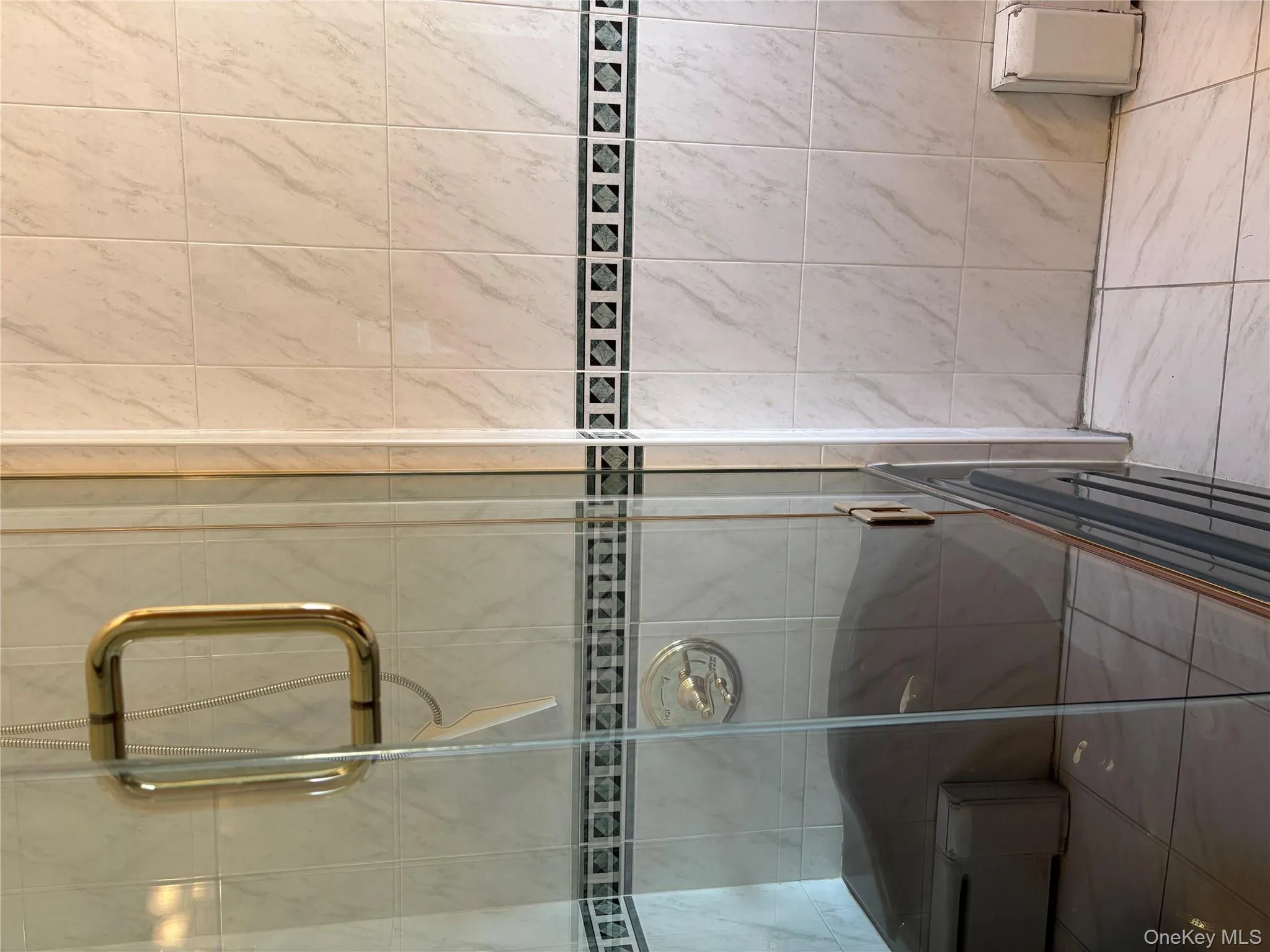 Bathroom featuring a stall shower, baseboard heating, and tile walls Bathroom featuring a stall shower, baseboard heating, and tile walls