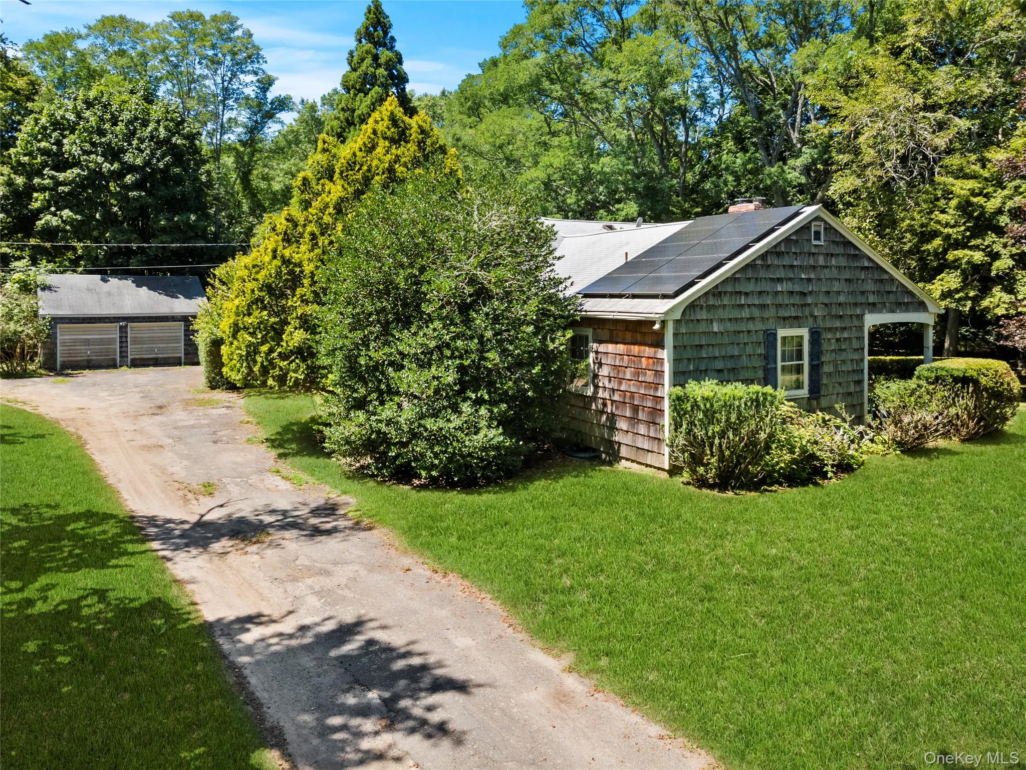 View of front of home featuring solar panels, a front yard, and garage View of front of home featuring solar panels, a front yard, and garage