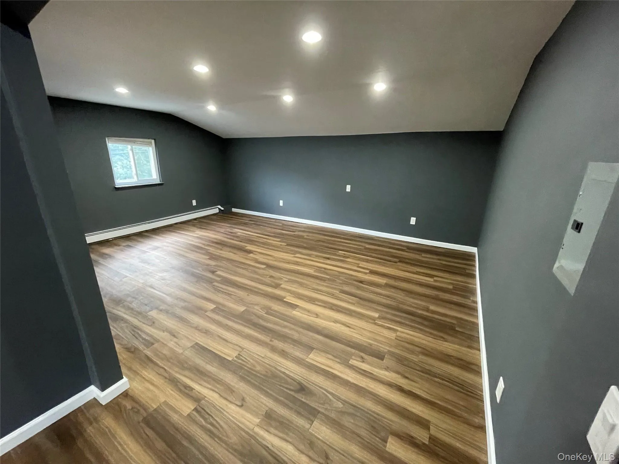Spare room with lofted ceiling, wood finished floors and recessed lighting. Spare room with lofted ceiling, wood finished floors and recessed lighting.