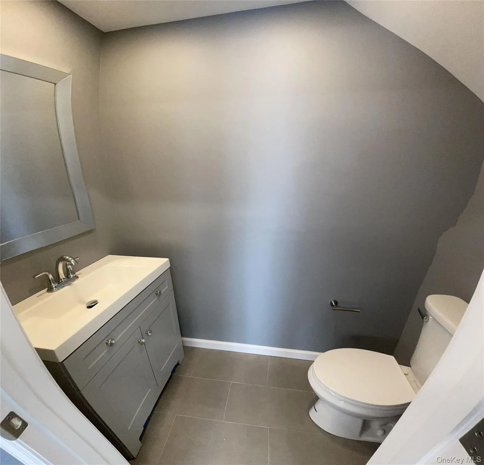 Half bath featuring light tile patterned floors and vanity on main floor. Half bath featuring light tile patterned floors and vanity on main floor.