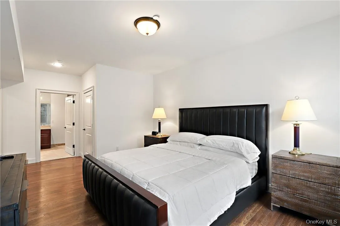 Bedroom featuring hardwood / wood-style flooring and ensuite bath Bedroom featuring hardwood / wood-style flooring and ensuite bath