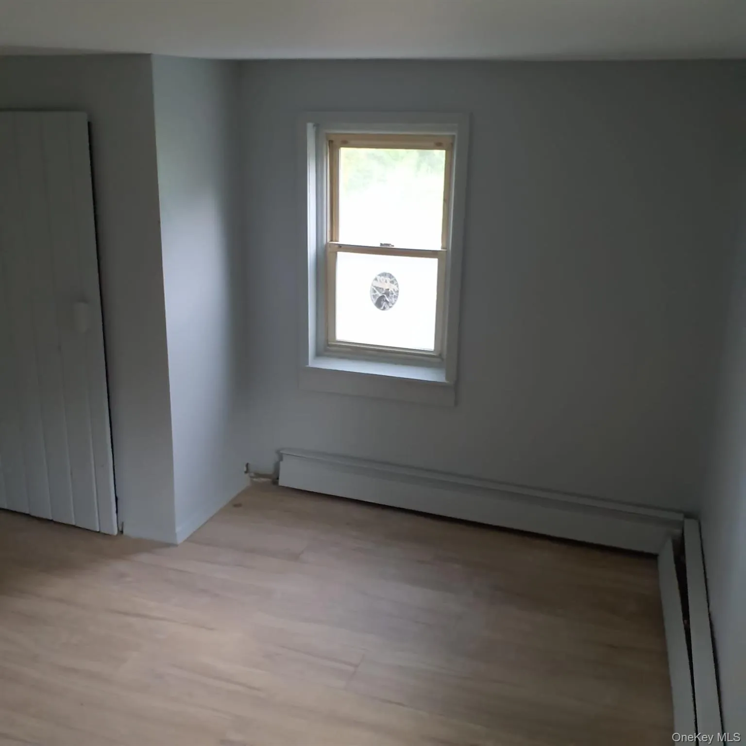 Spare room with light wood-style flooring and baseboard heating Spare room with light wood-style flooring and baseboard heating