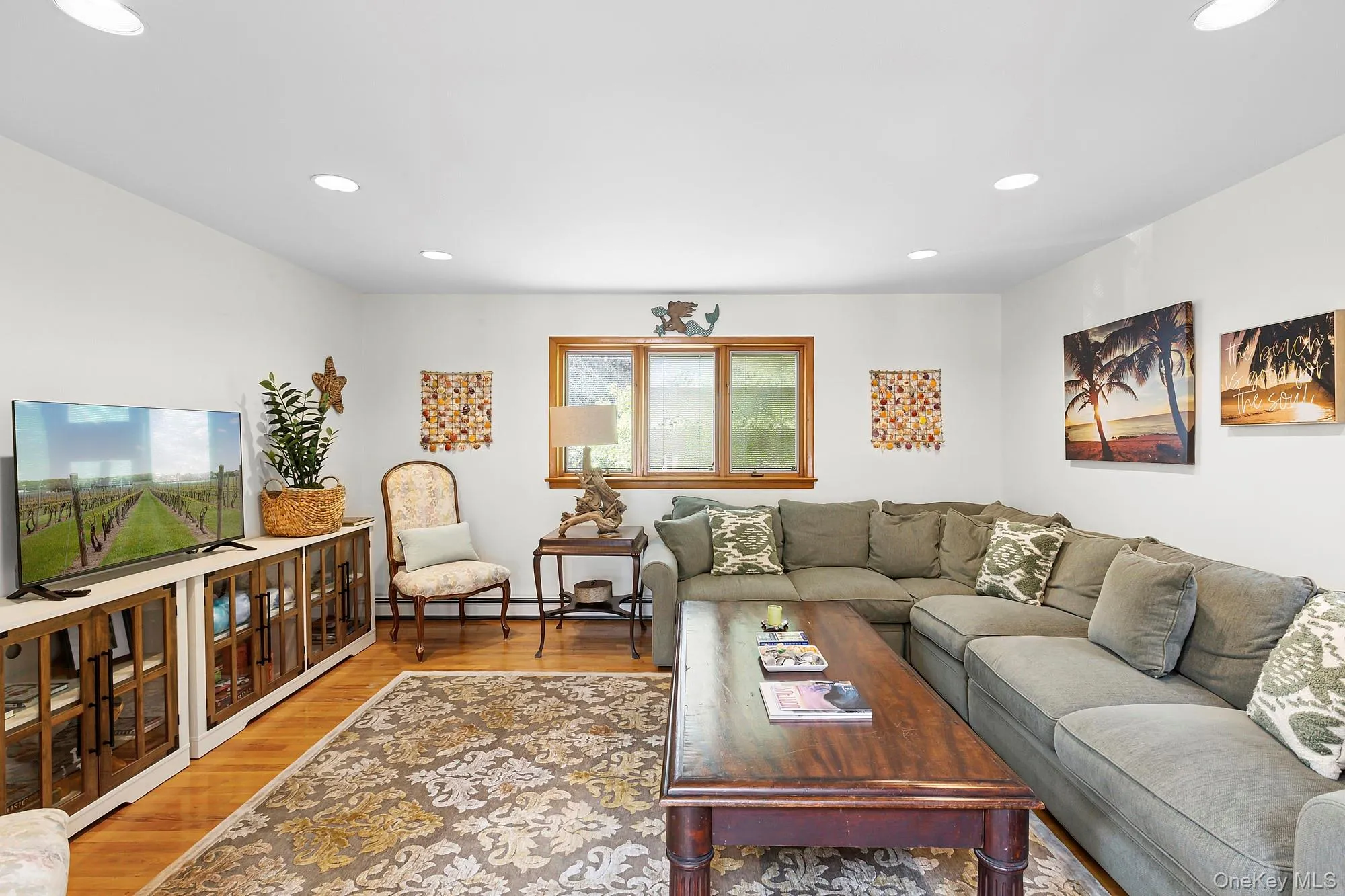Living area featuring recessed lighting, wood finished floors, and baseboard heating Living area featuring recessed lighting, wood finished floors, and baseboard heating