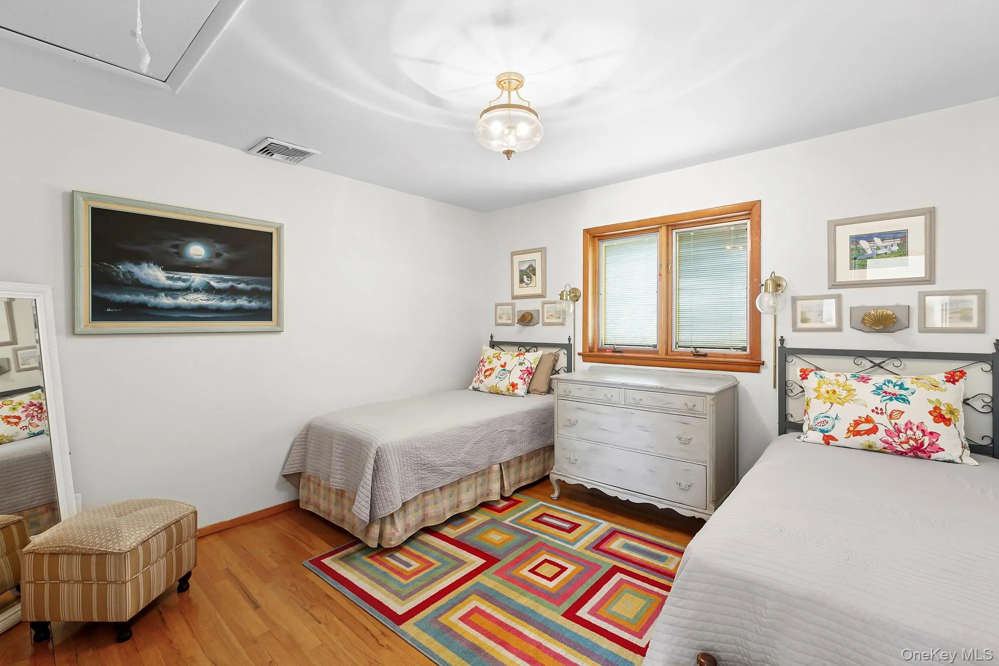 Bedroom with wood finished floors and attic access Bedroom with wood finished floors and attic access