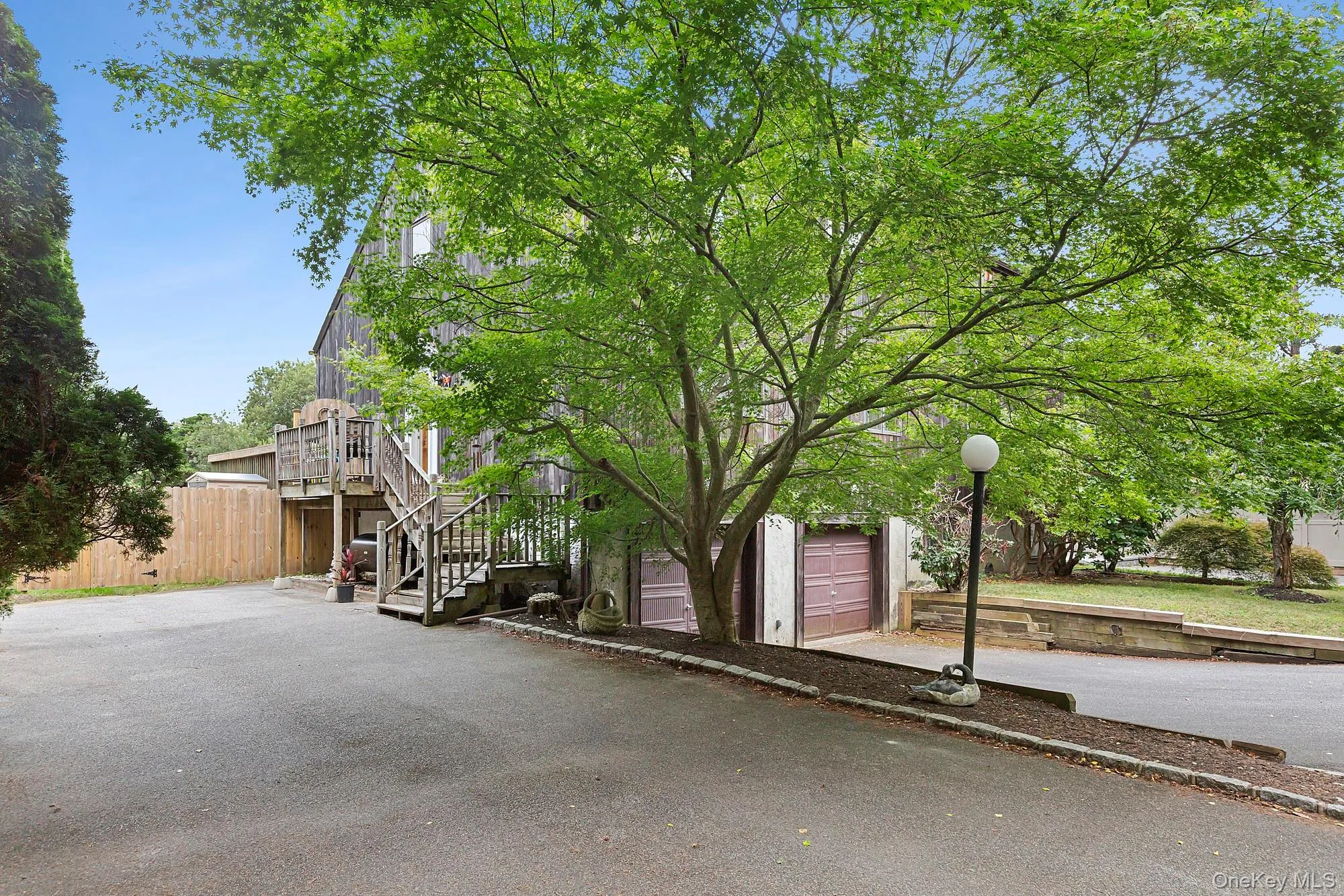View of front facade with stairway, a garage, asphalt driveway, and a deck View of front facade with stairway, a garage, asphalt driveway, and a deck