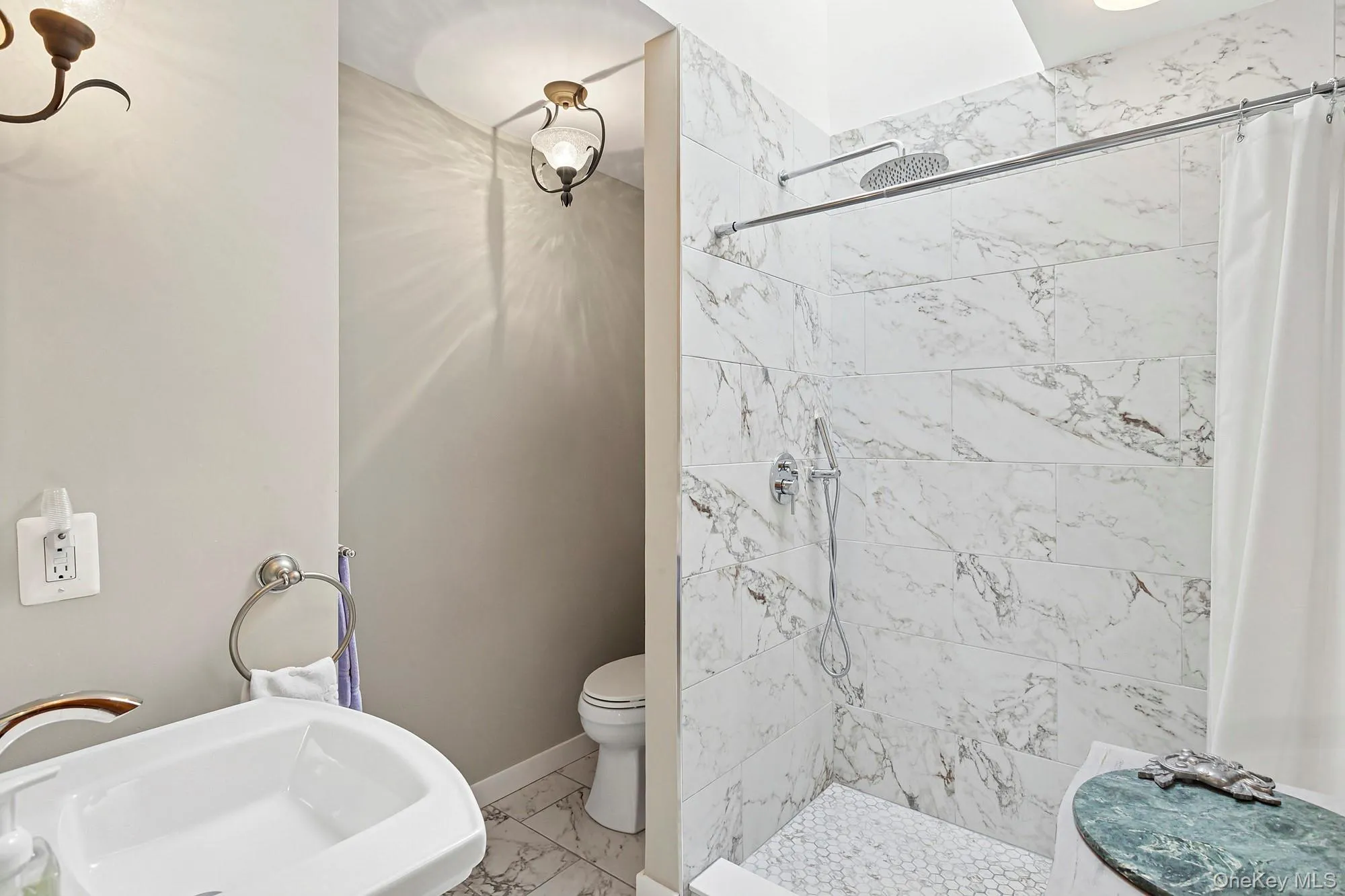 Bathroom featuring a shower stall and light marble finish flooring Bathroom featuring a shower stall and light marble finish flooring