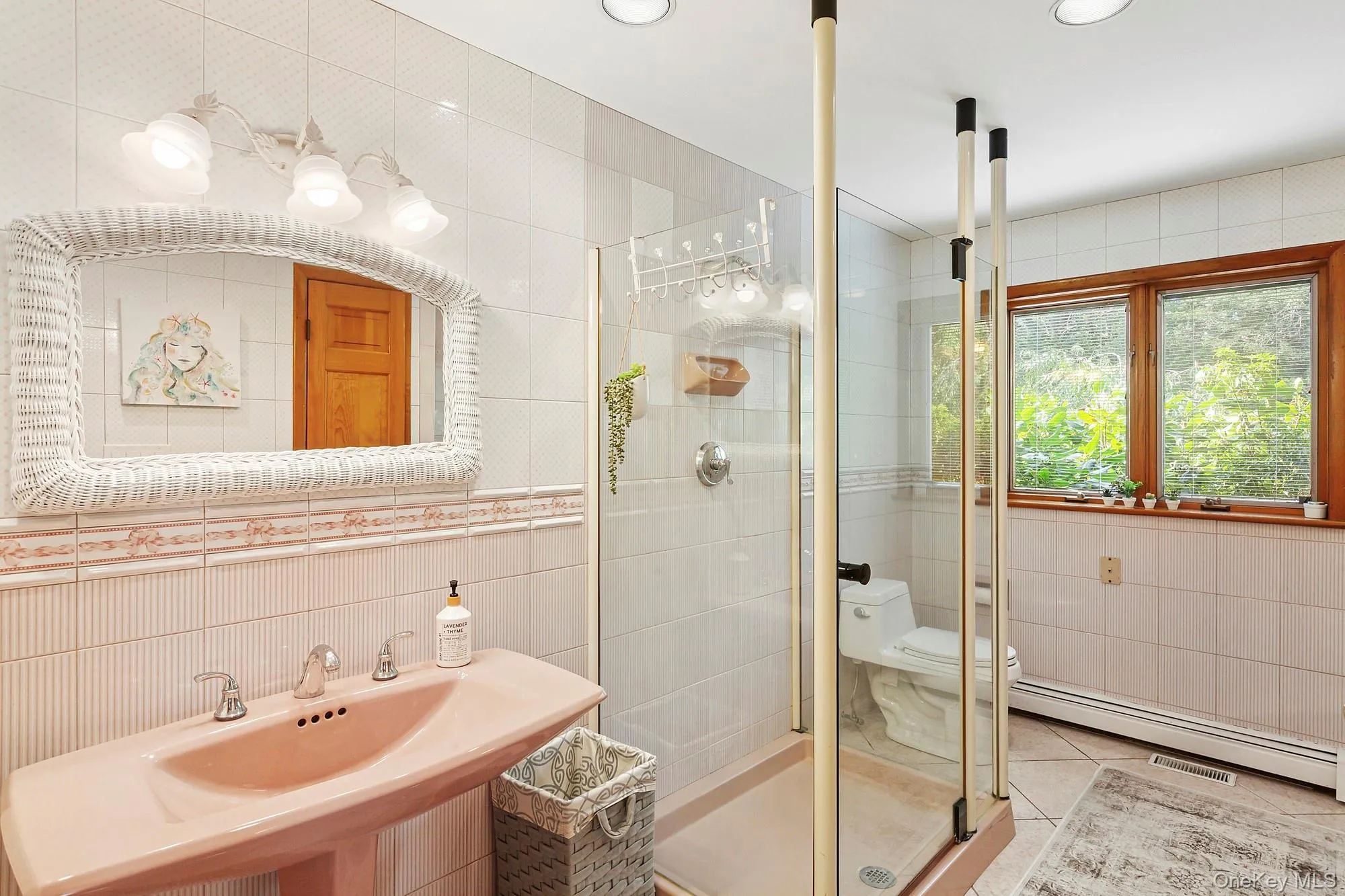 Bathroom featuring tile walls, a shower stall, tile patterned floors, and a baseboard radiator Bathroom featuring tile walls, a shower stall, tile patterned floors, and a baseboard radiator