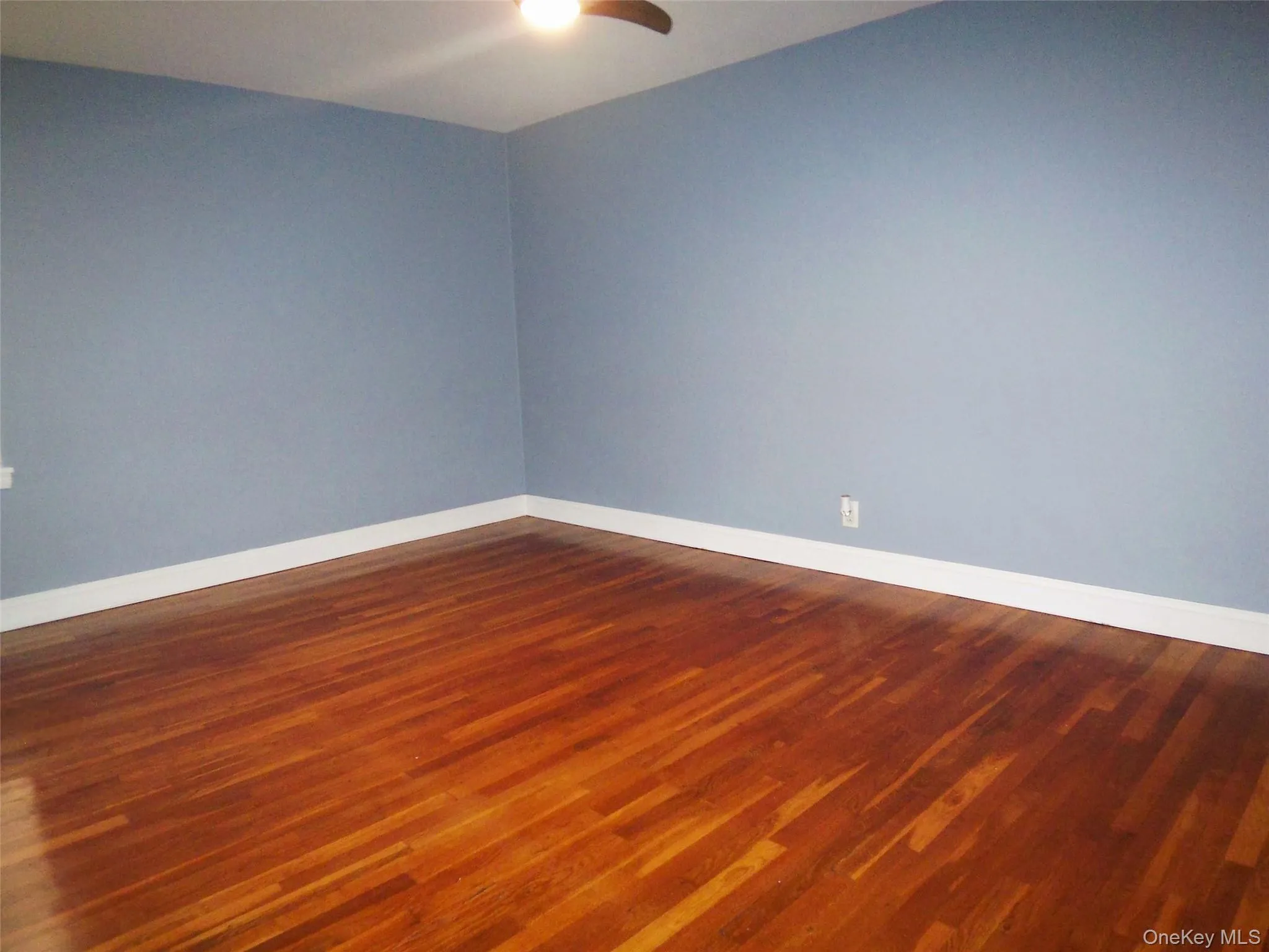 Empty room with baseboards and dark wood finished floors Empty room with baseboards and dark wood finished floors