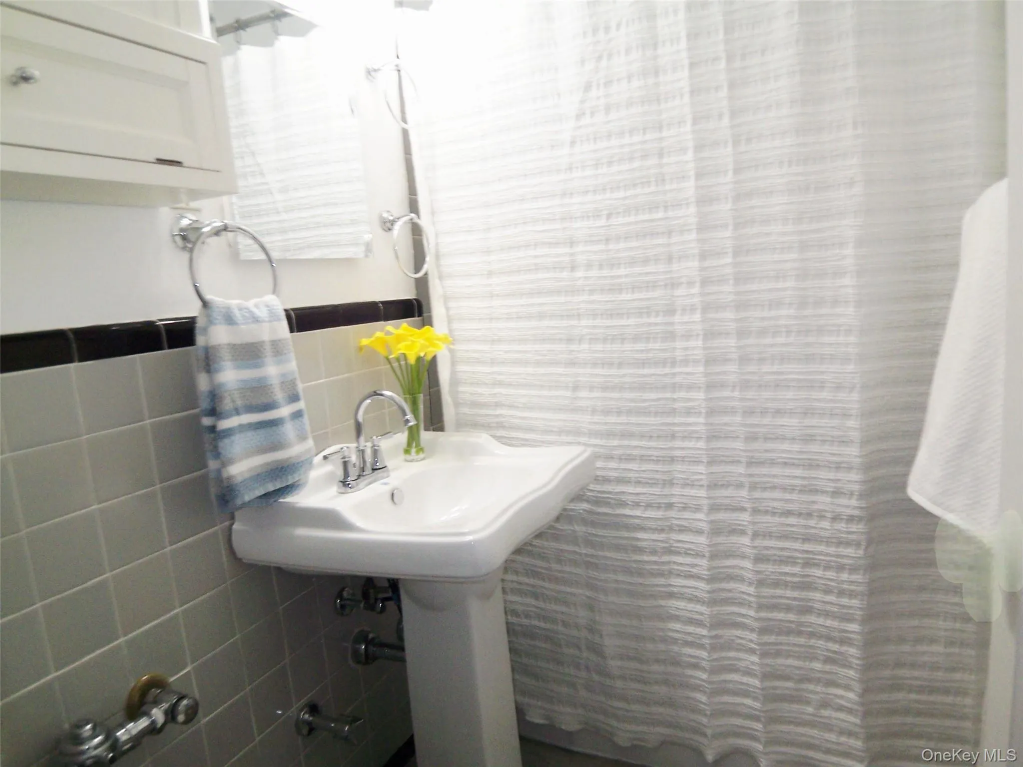 Full bathroom featuring tile walls and curtained shower Full bathroom featuring tile walls and curtained shower